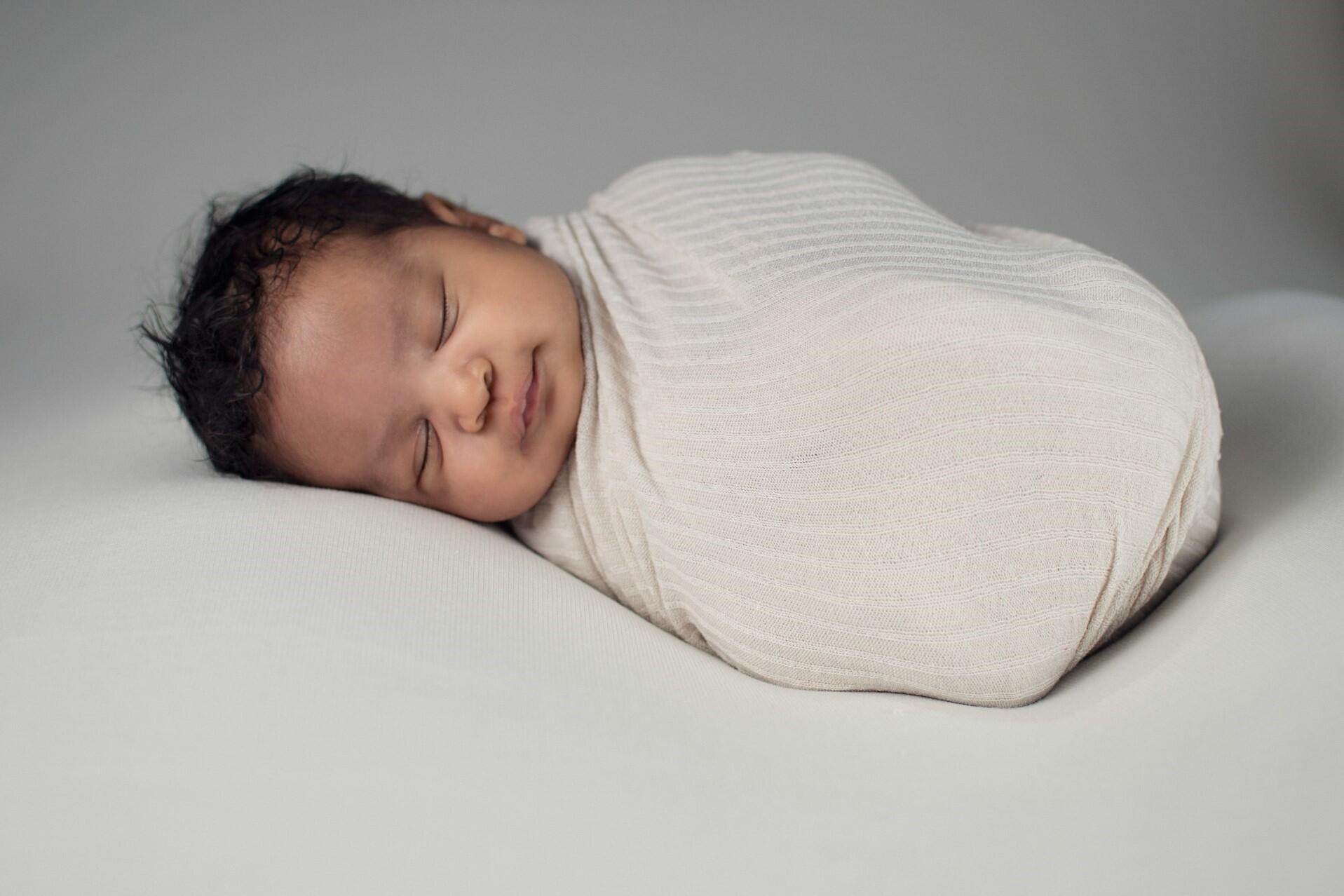 newborn baby sleeping wrapped in blanket