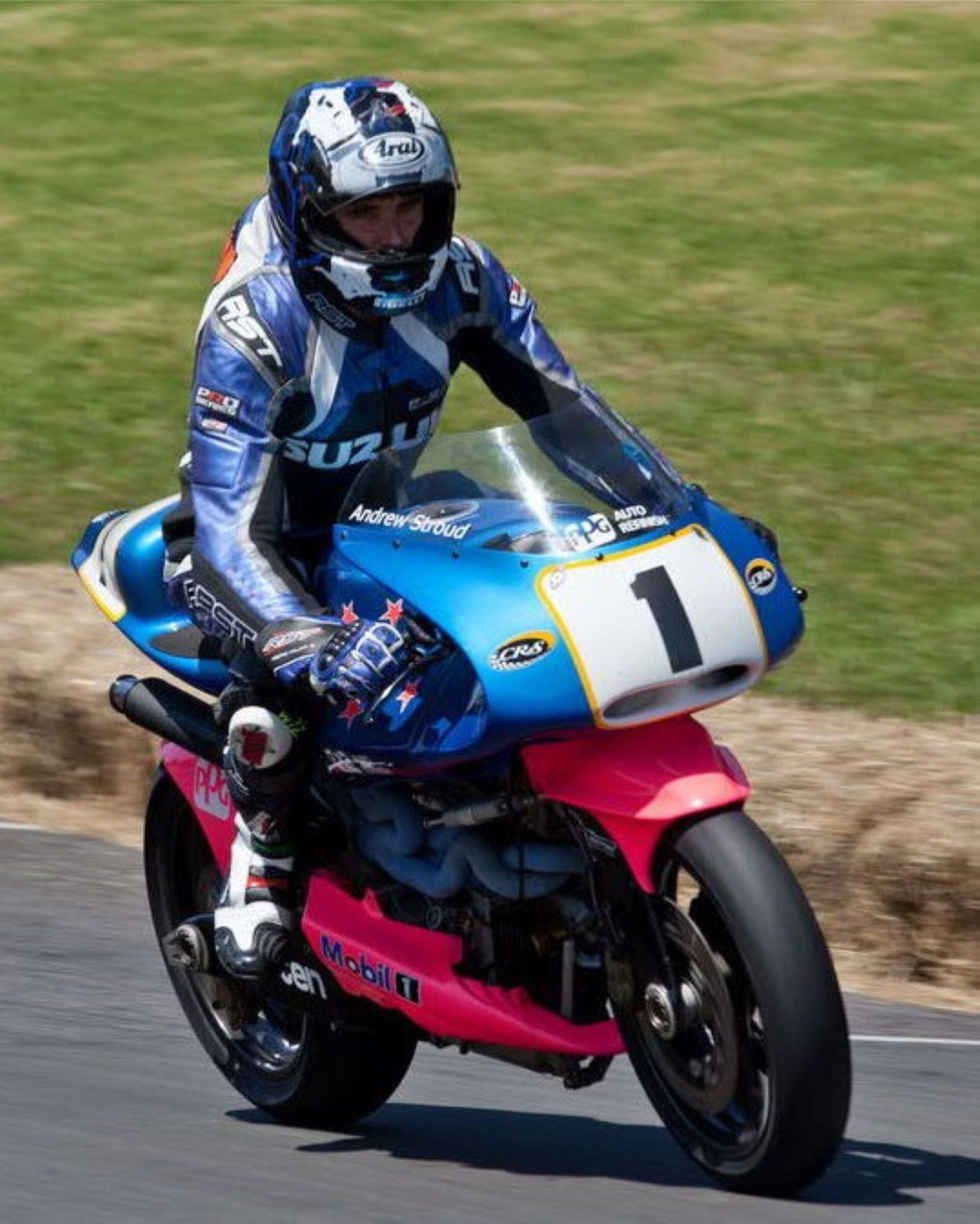 Motorcycle rider wearing helmet riding a Britten V1000 racing bike on a track