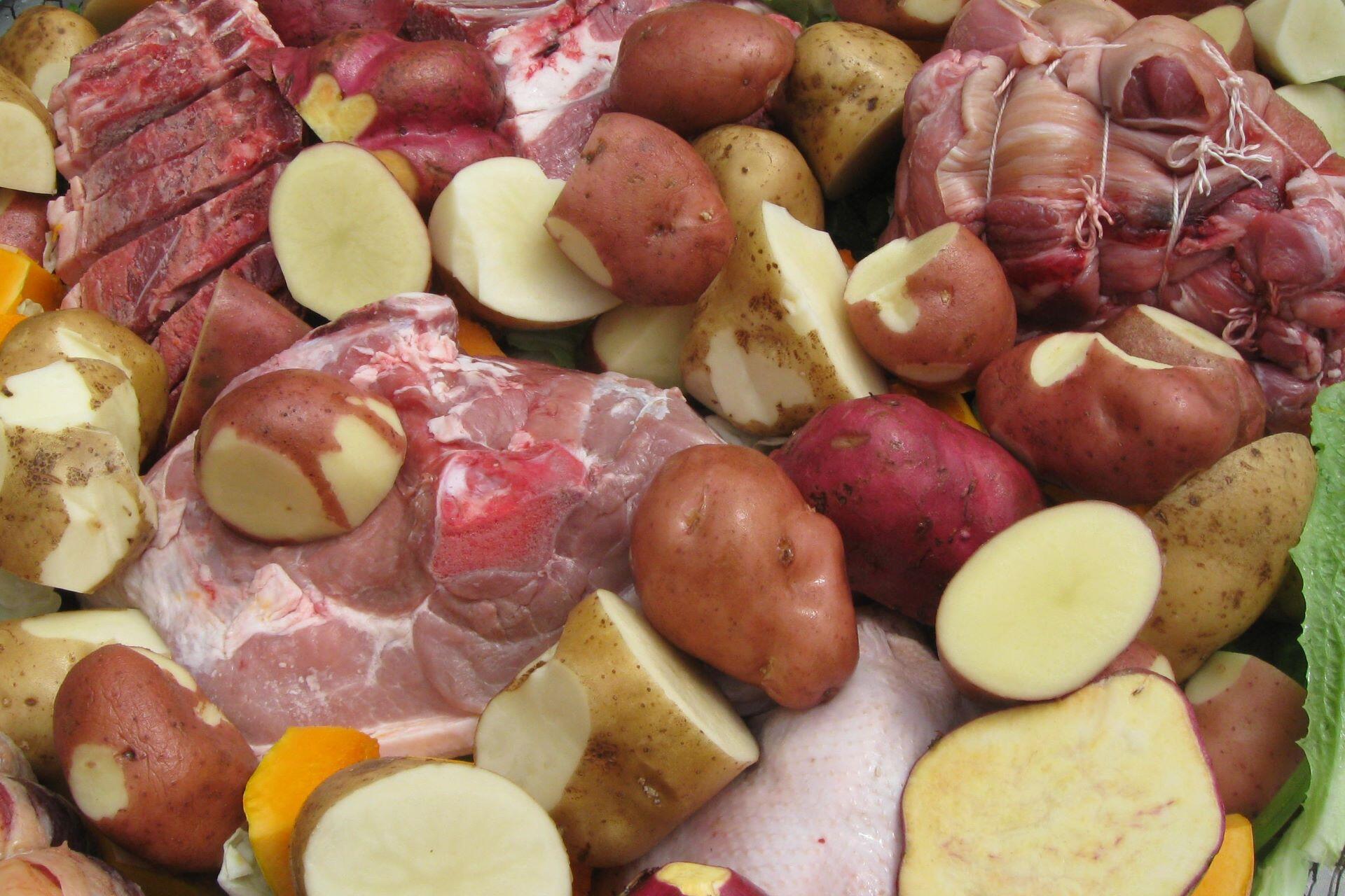 Raw meat and chopped potatoes prepared together for cooking in a hāngī