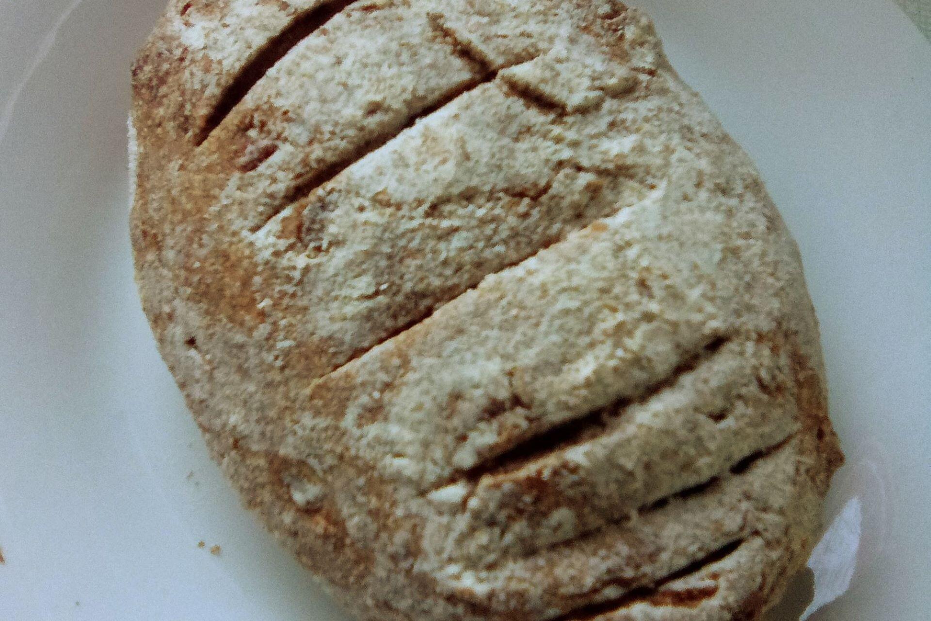 Round loaf of rewena bread with a scored top crust on a plate