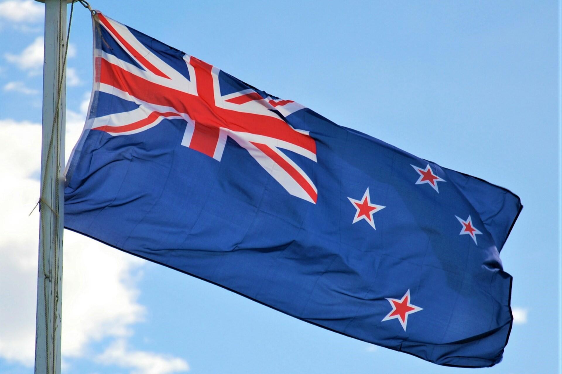 New Zealand flag flying against a blue sky