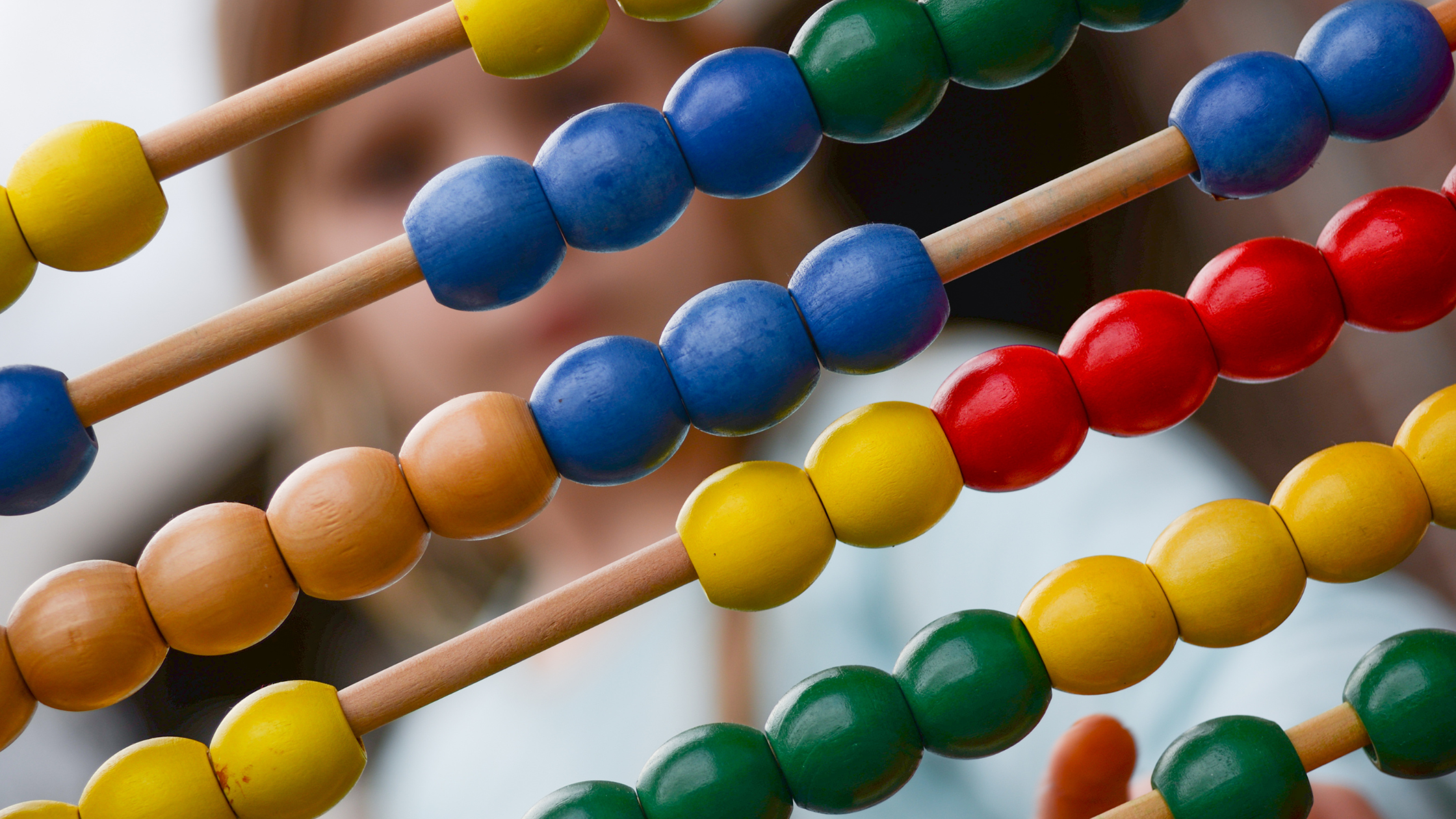 Ábaco de madera con cuentas de colores utilizado para la enseñanza de matemáticas a niños.
