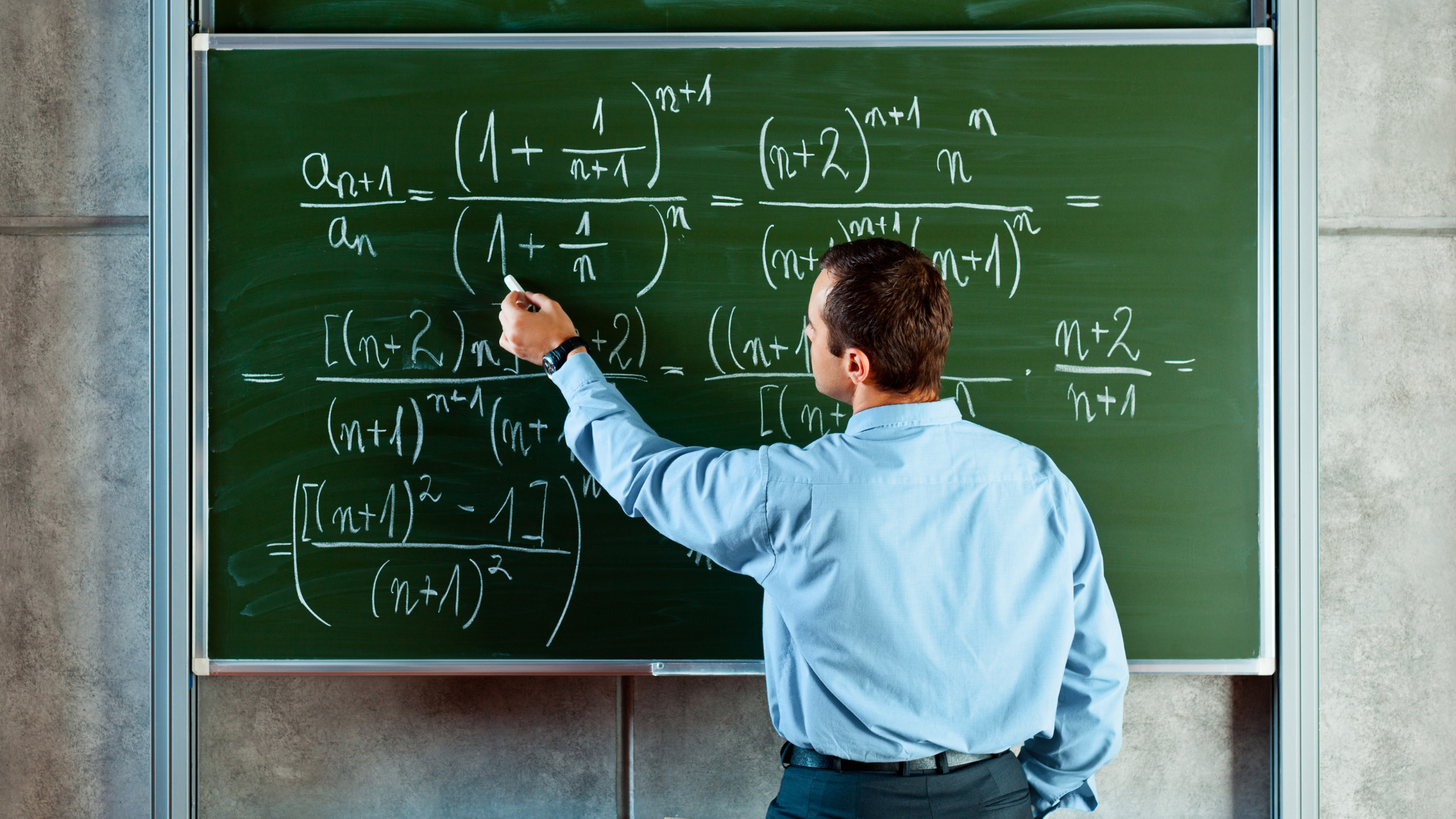 Profesor escribiendo ecuaciones matemáticas complejas en un pizarrón verde, explicando conceptos avanzados en el aula.