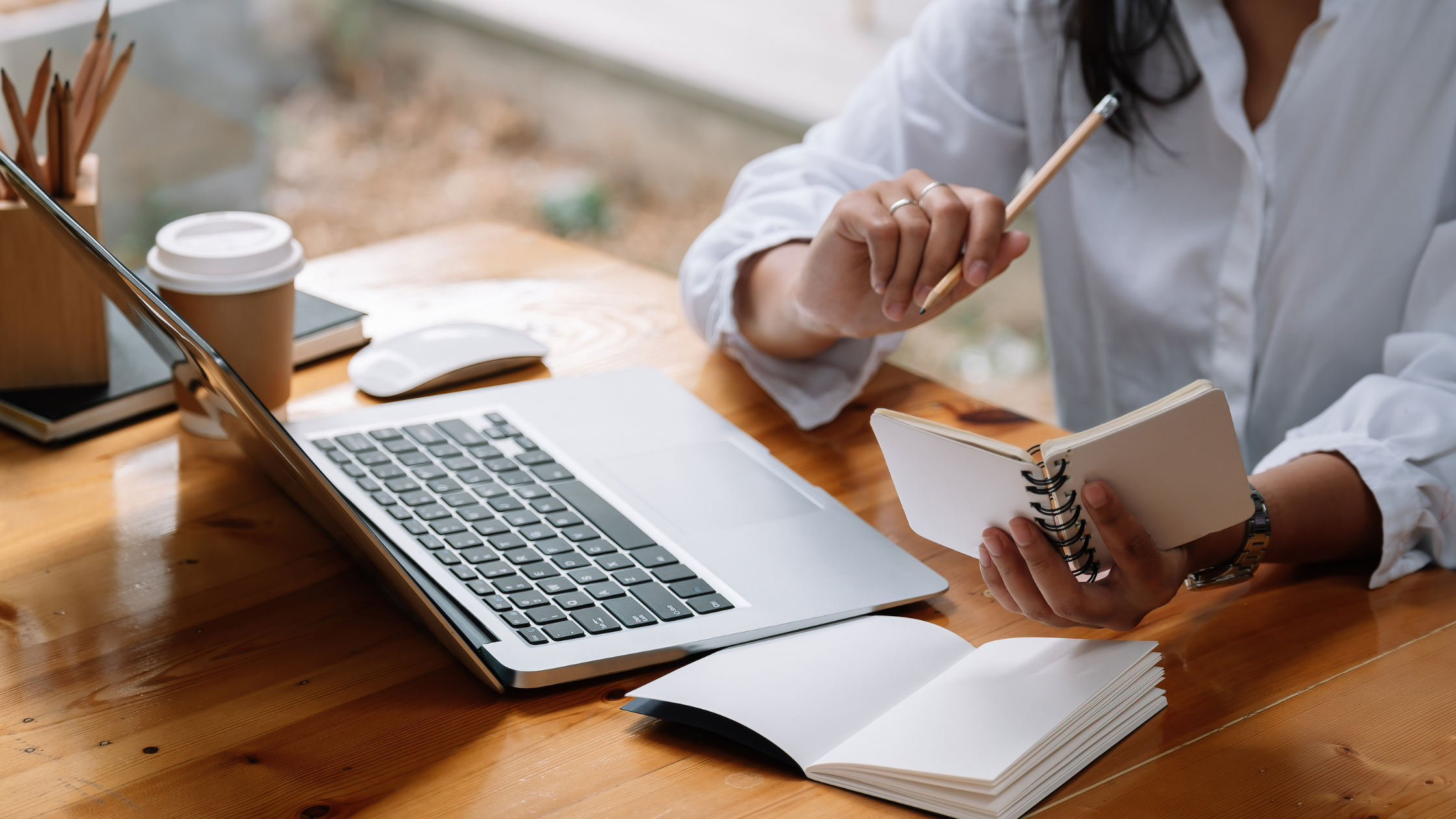 Estudio frente a una laptop con libreta en mano.