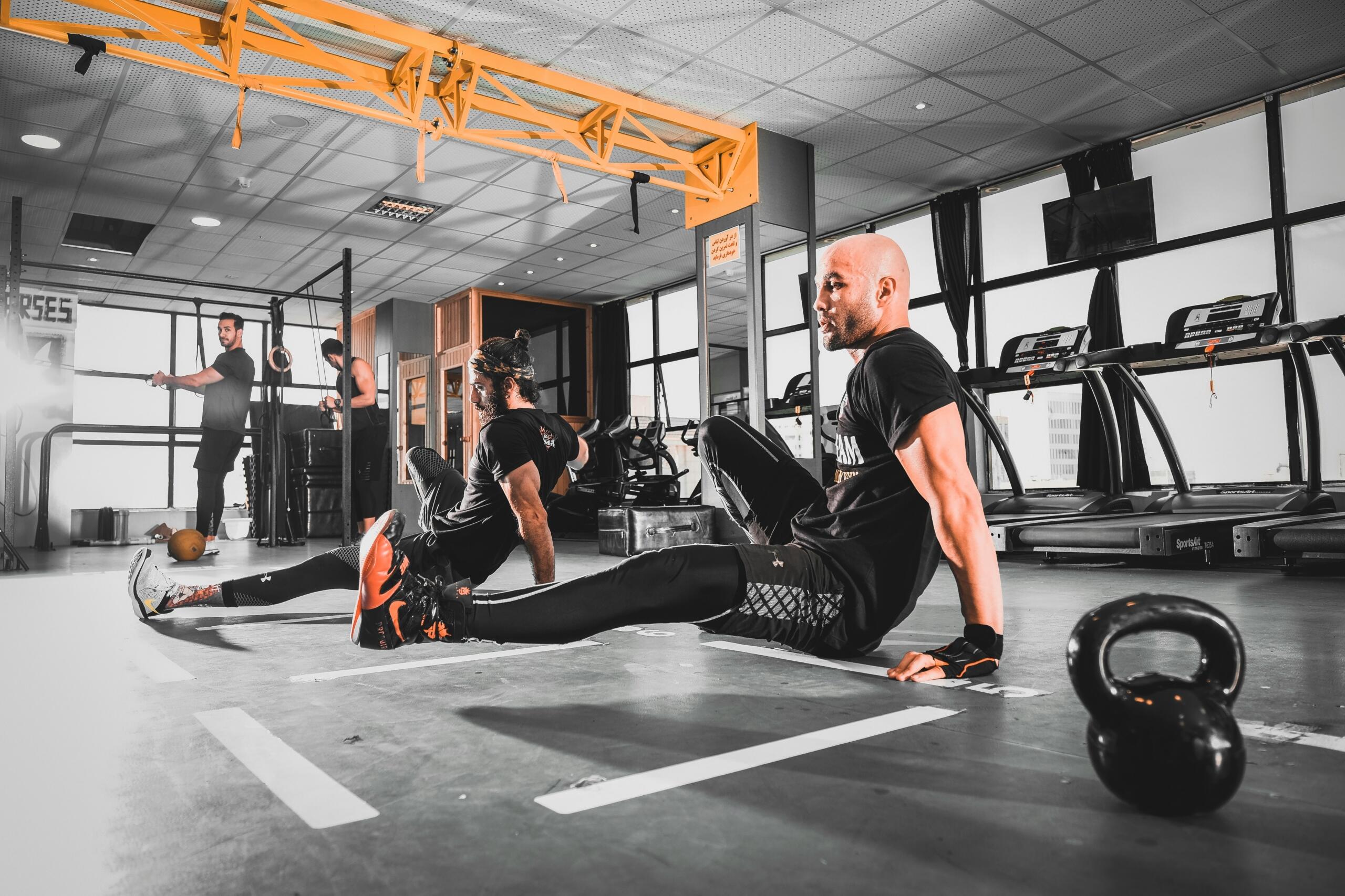 Personas entrenando en un gimnasio moderno con enfoque en ejercicios funcionales.