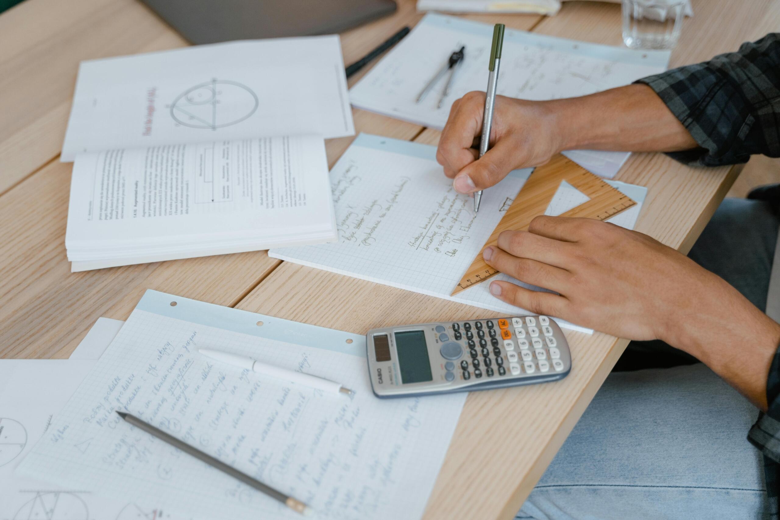 Pizarra con circuito electrónico dibujado con tiza blanca y notas adhesivas sobre tareas de química y matemáticas.