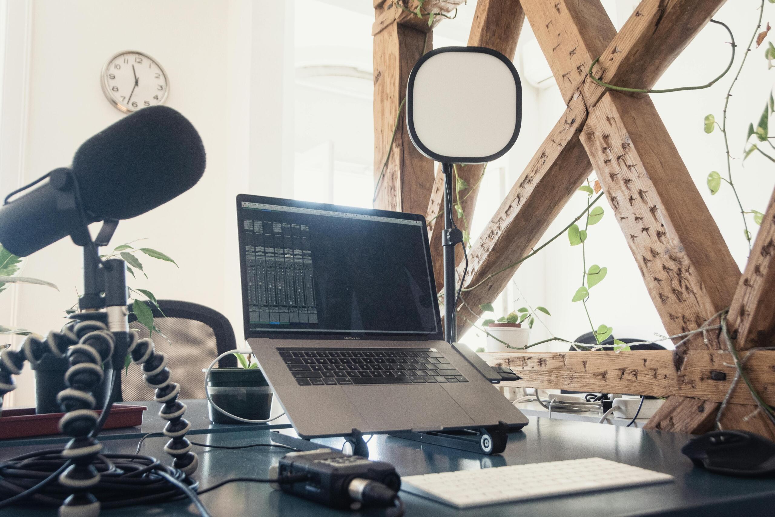 Estudio de grabación casero con micrófono profesional, laptop y equipo de audio para producción musical.