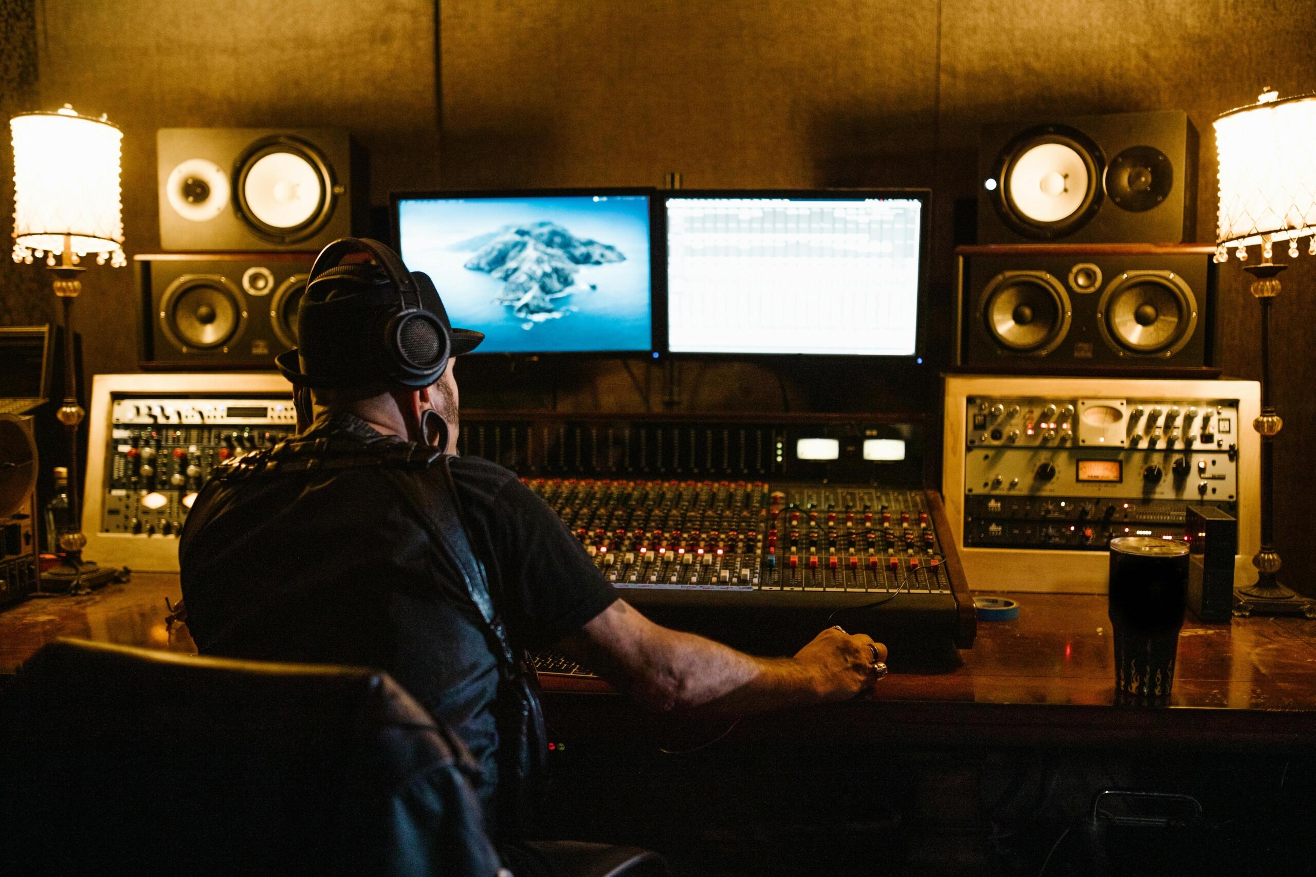 Ingeniero de sonido mezclando pistas en estudio profesional con monitores de audio y consola de mezcla de gran escala.