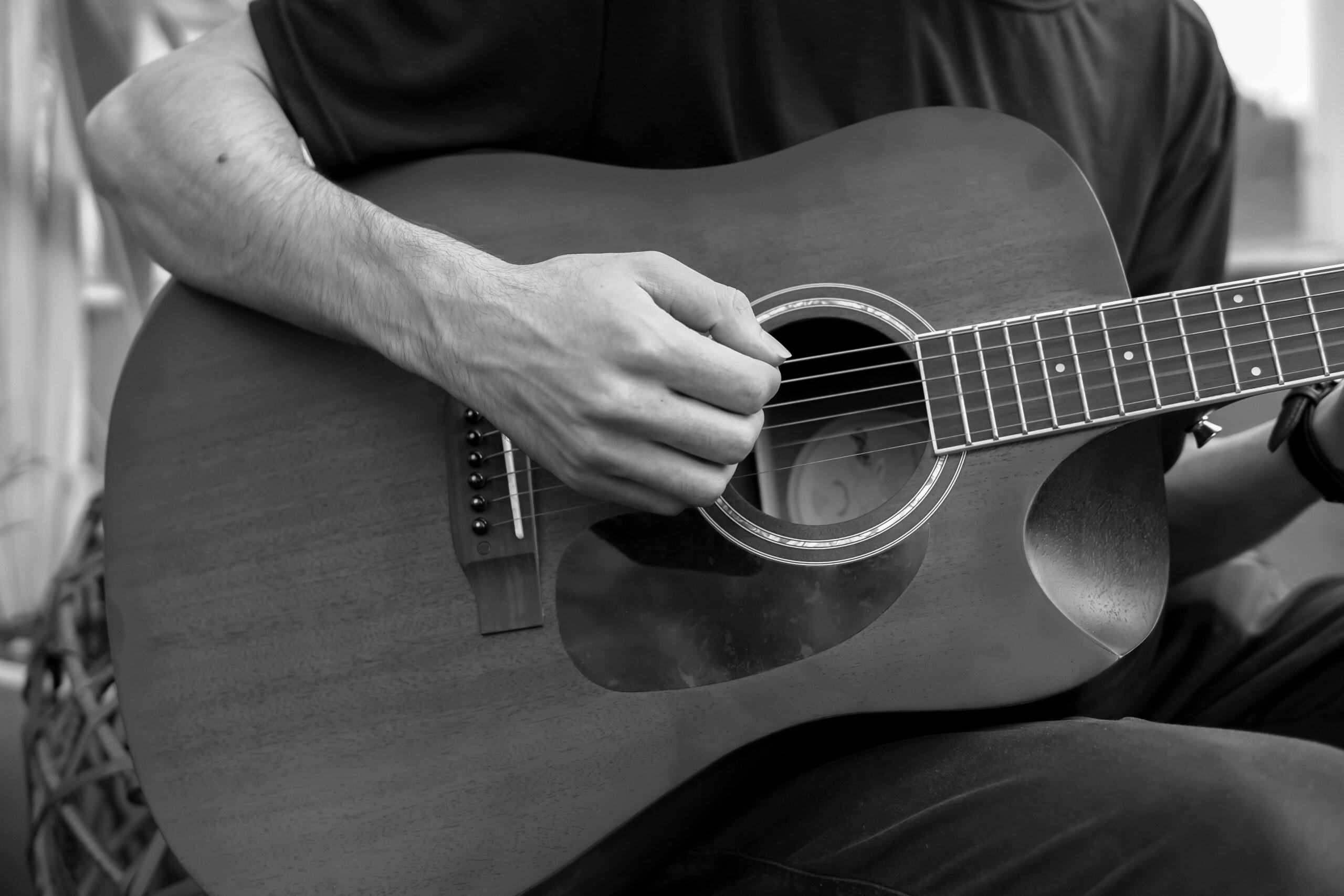 Primer Plano De Un Músico Tocando La Guitarra Acústica