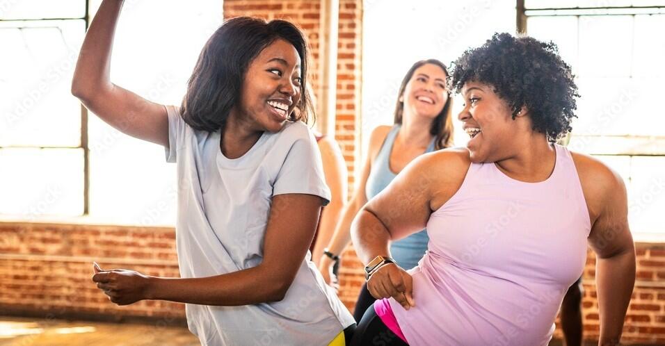 Group of diverse women dancing joyfully in a studio.