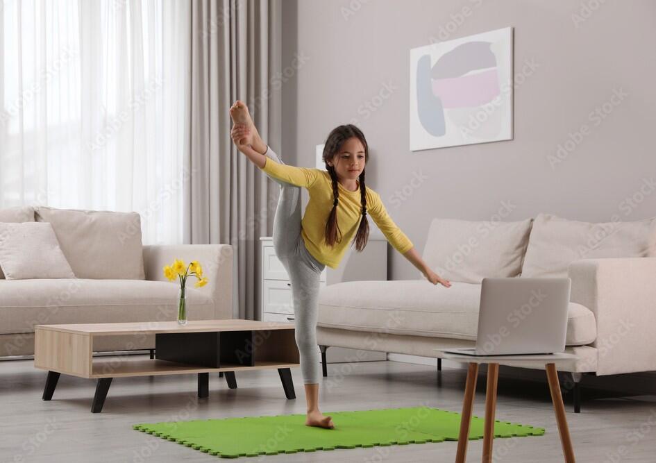 Cute little girl taking online dance class at home 