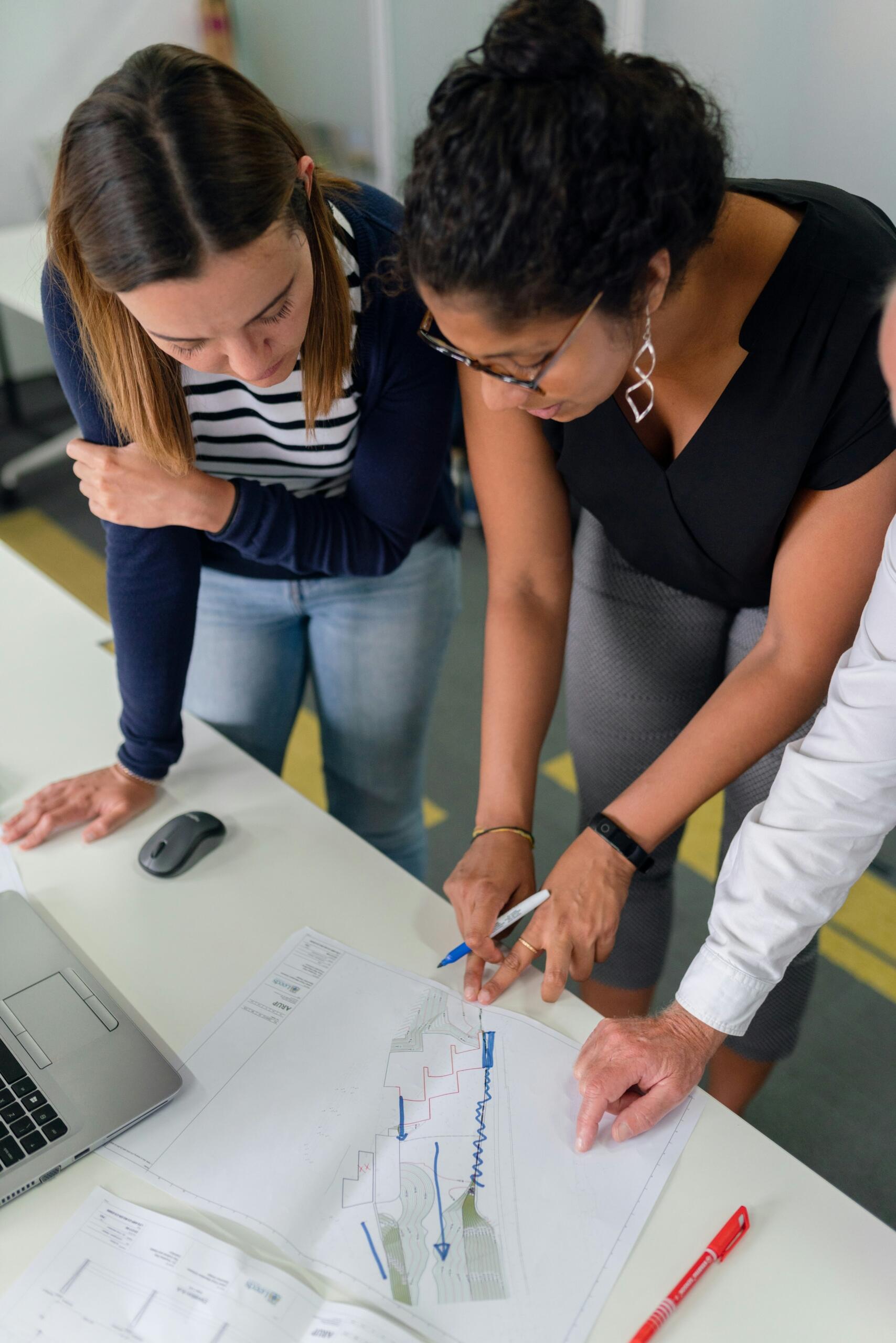 Grupo de personas revisando y analizando documentos contables en una mesa de trabajo.