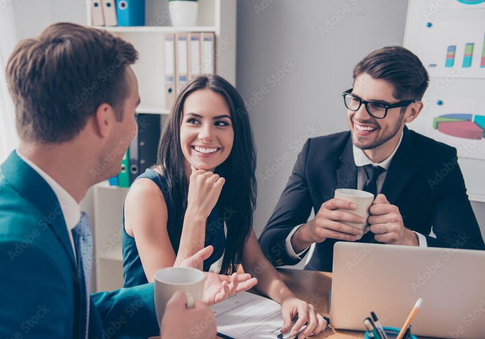 Cheerful office workers discussing their project over cup of te 