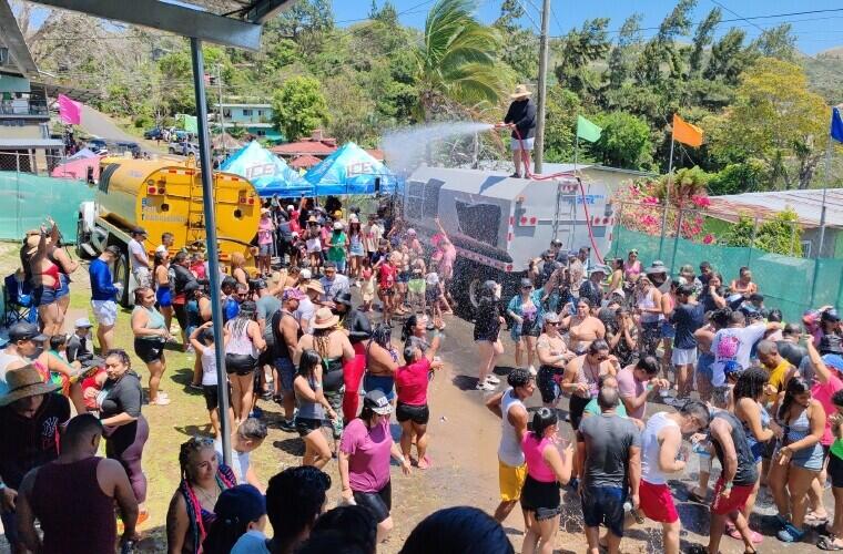 Camión cisterna rociando agua sobre la multitud durante los culecos del carnaval panameño.