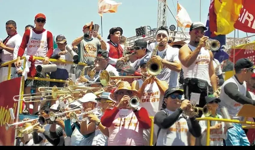 Murga panameña tocando trompetas y trombones durante desfile de carnaval.