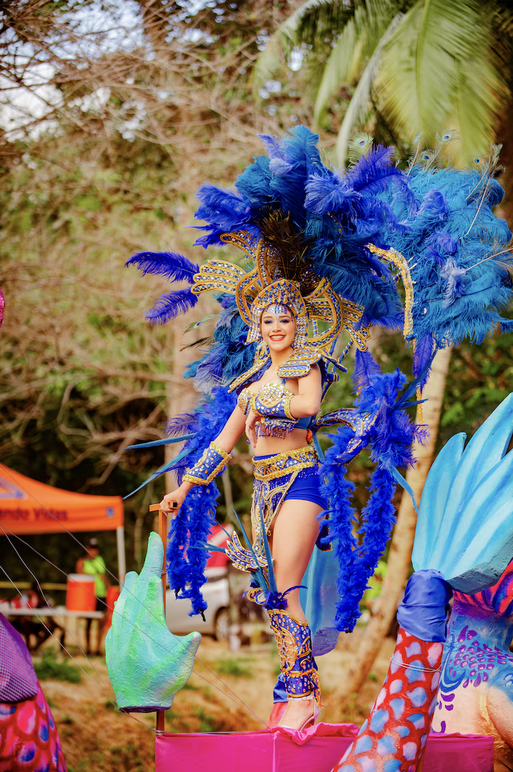 Carroza con dragón azul iluminado y reina con plumas turquesas en desfile nocturno del Carnaval de Panamá.