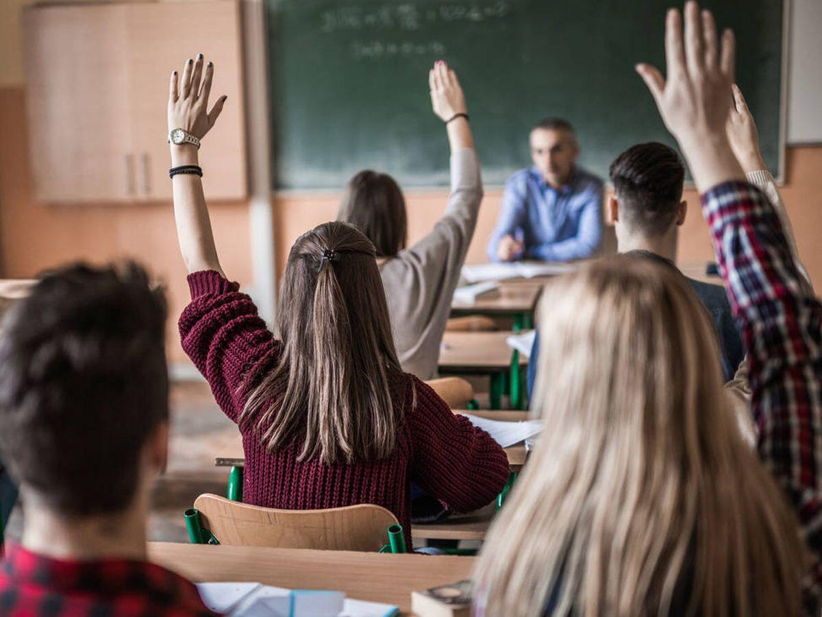 Tutor explicando mientras estudiantes prestan atención
