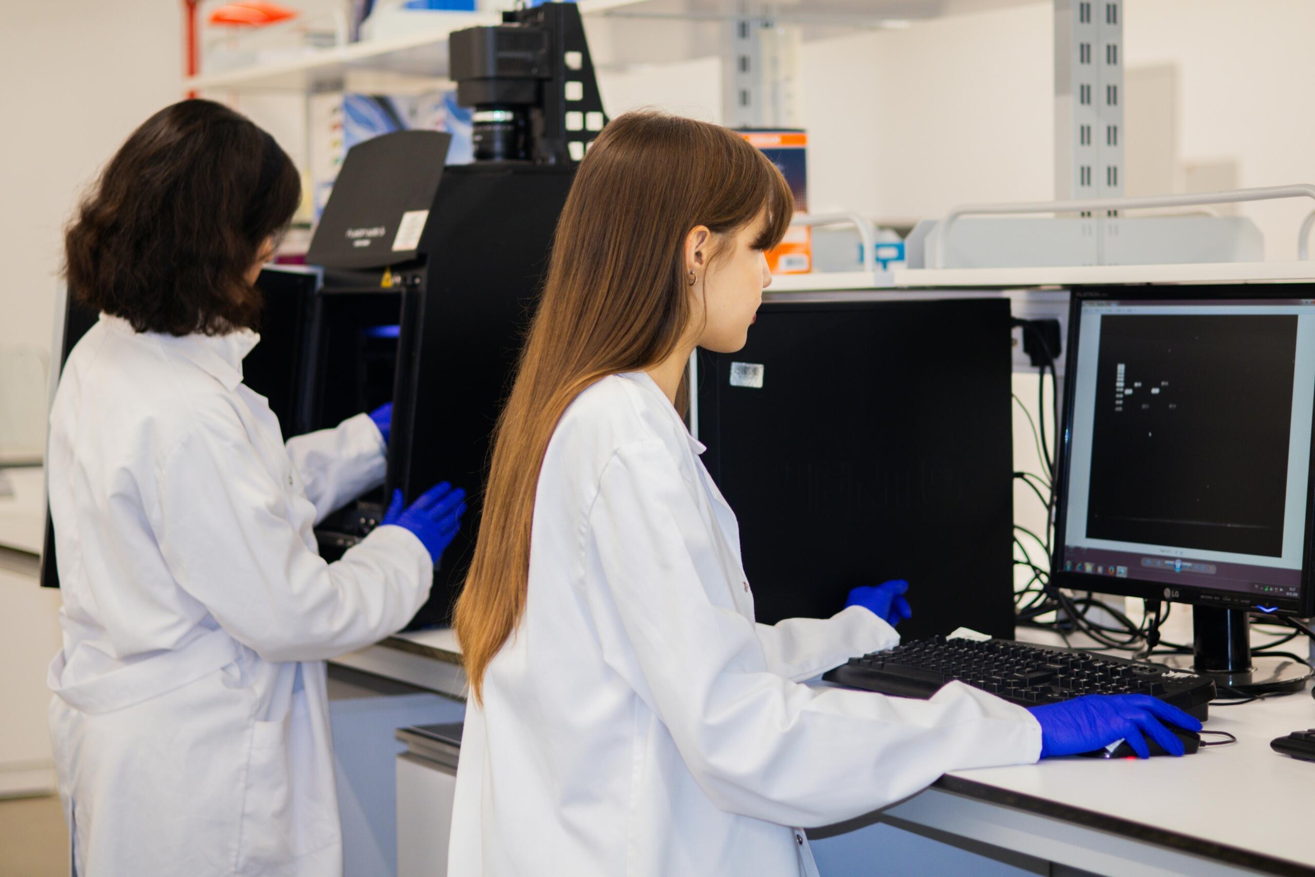 Estudiantes de biología analizando resultados en un laboratorio universitario.