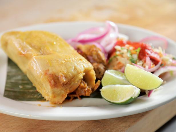 humita en un plato con incurtido y unos trocitos de limón