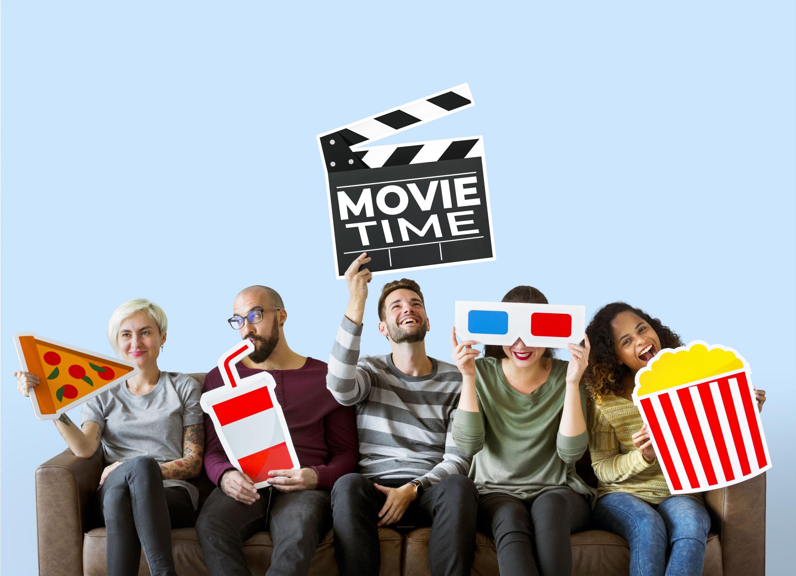 grupo de cinco amigo s en un sillon sosteniendo carteles con iconos MOVIE TIME