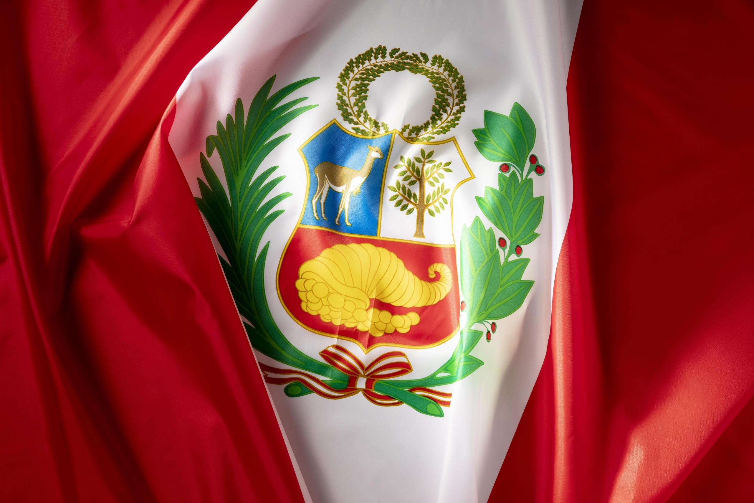 bandera del peru en primer plano con el escudo nacional