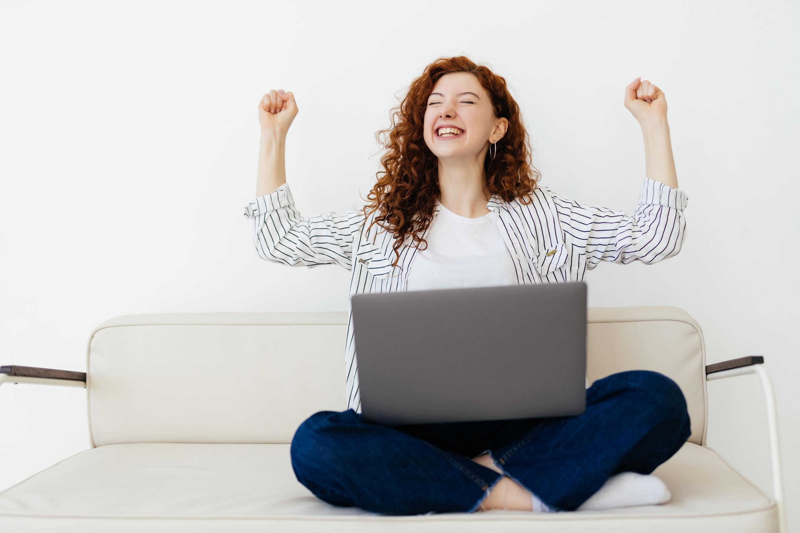 chica feliz tomando clases online desde su laptop
