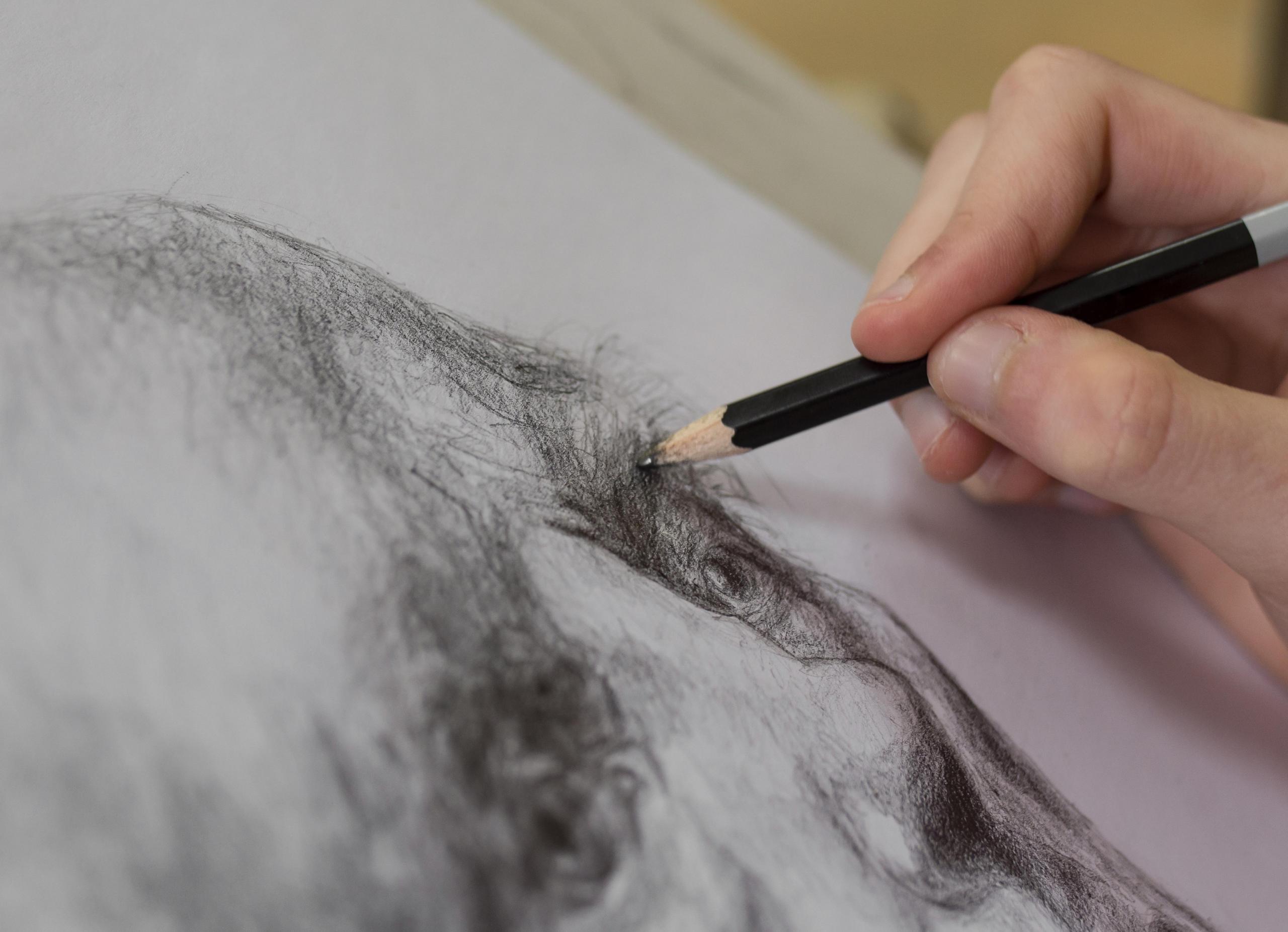 mano dibujando a lapiz un retrato realista de un hombre