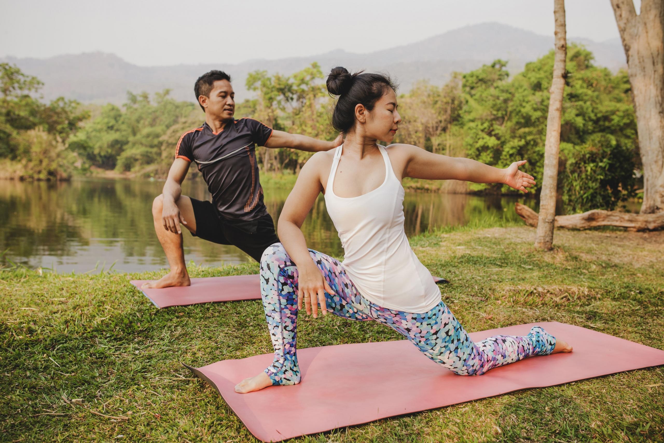 una pareja realizando yoga en medio de la naturaleza
