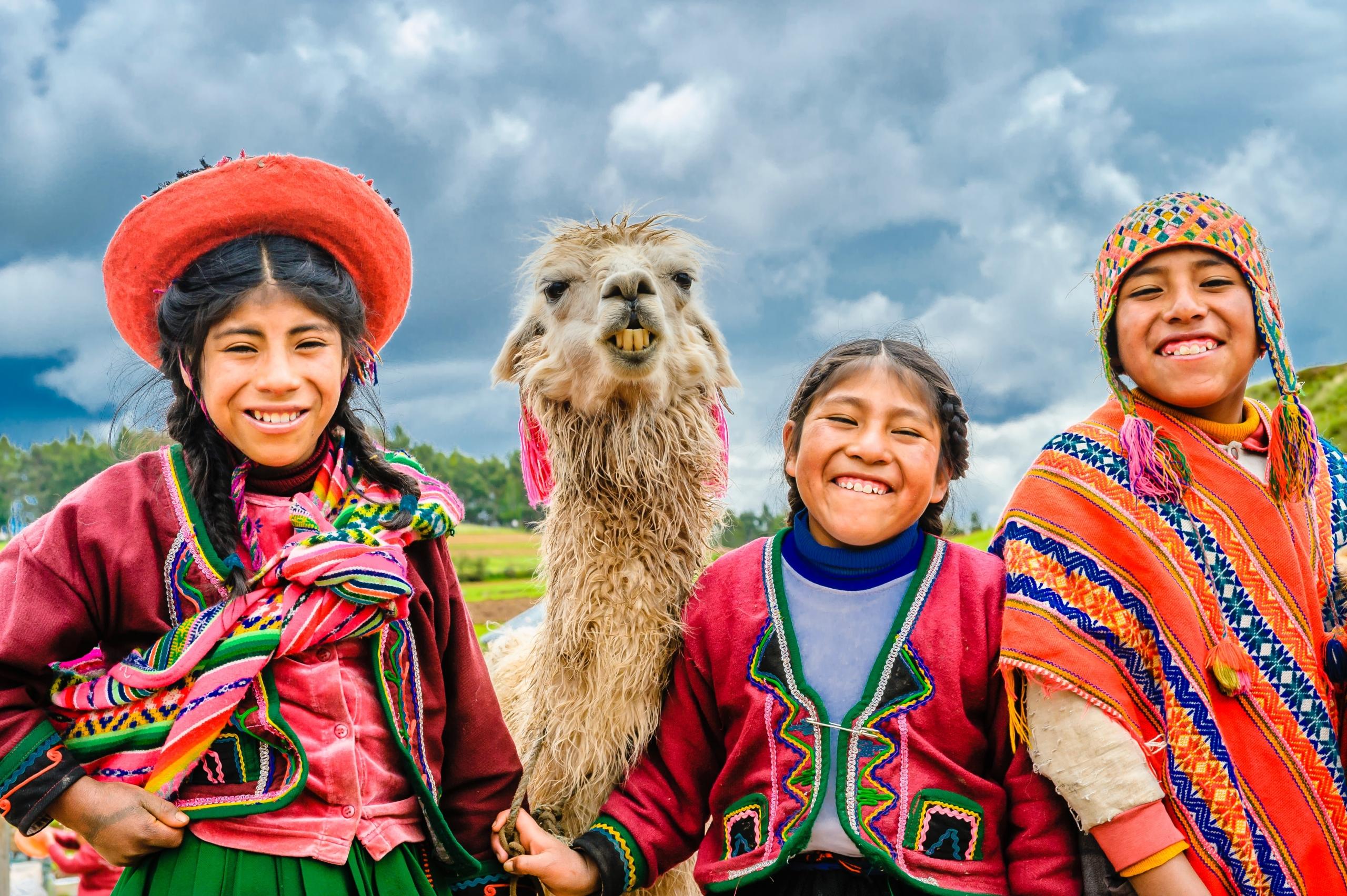 3 niños de la zona alto andina del Perú acompañado de una llama"