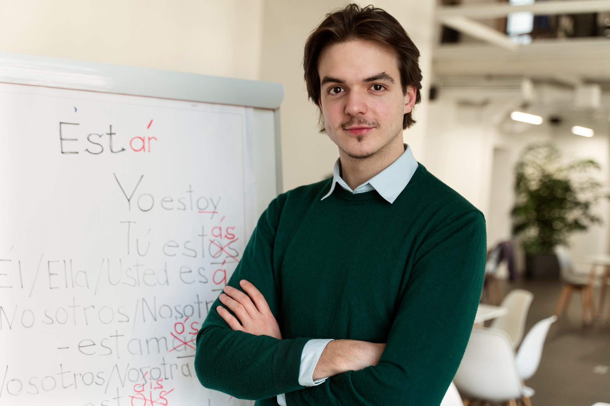 Profesor de español en frente de un tablero con palabras en español