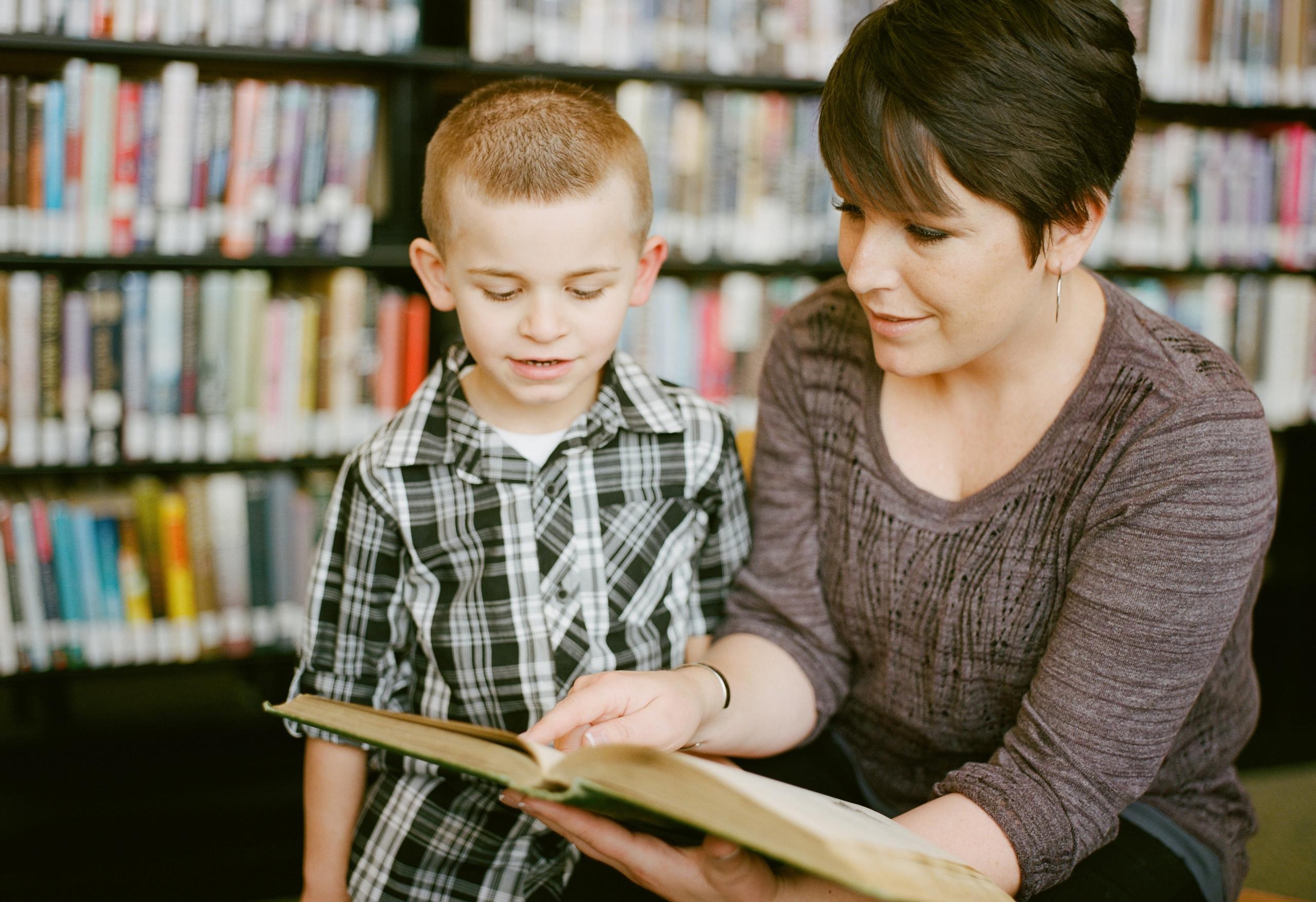 mujer leyendole un libro a un niño