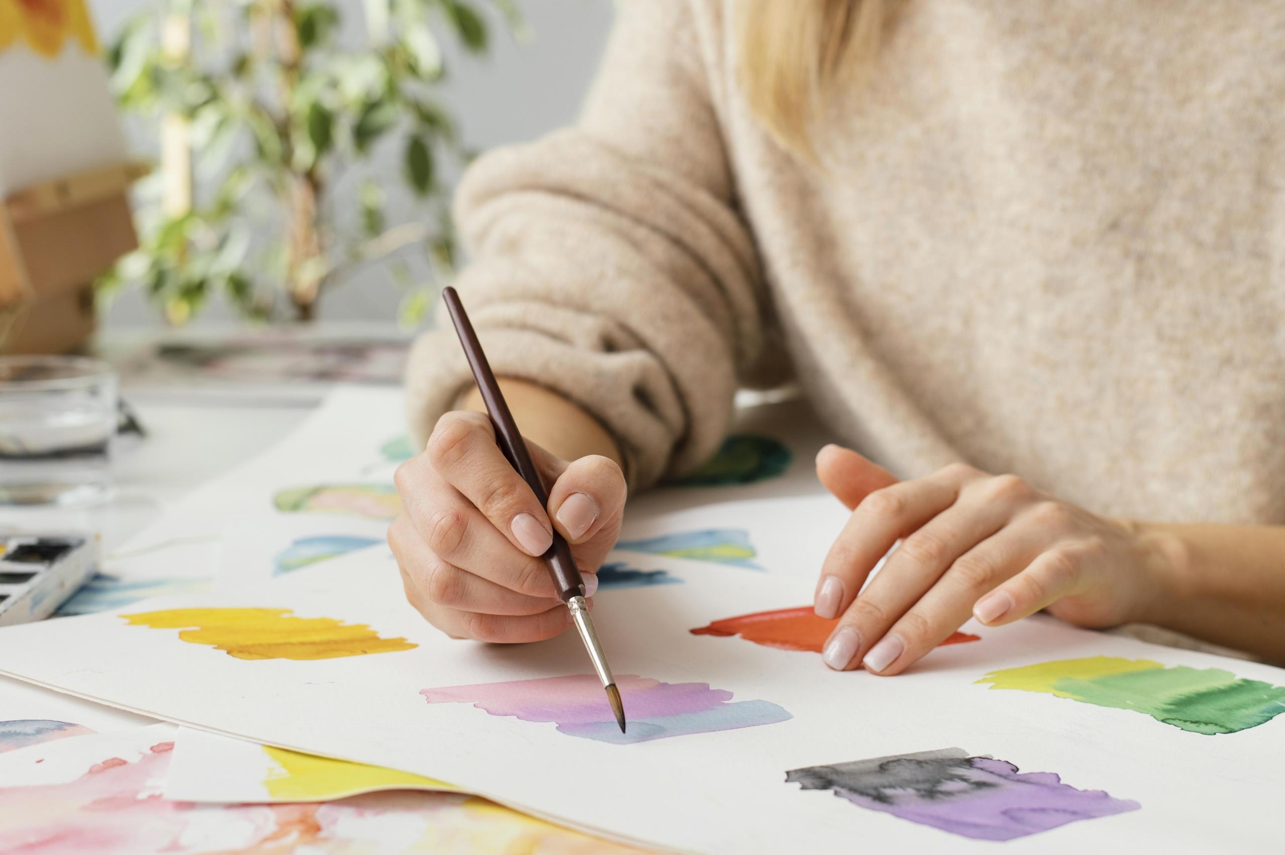 chica pintando muestras de color con acuarelas en una cartulina