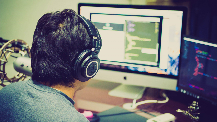 Un joven programando en su computadora