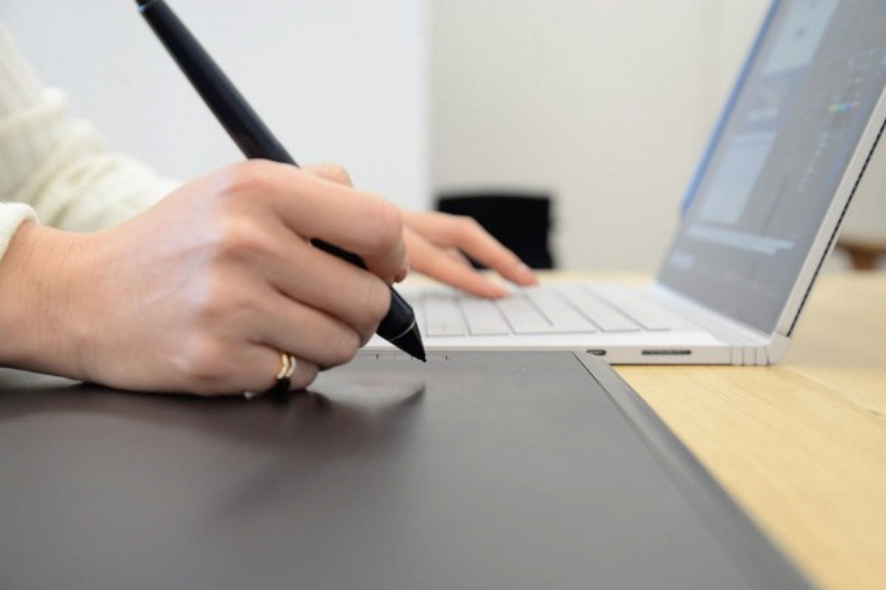 Una mujer dibujando en su wacom una obra digital