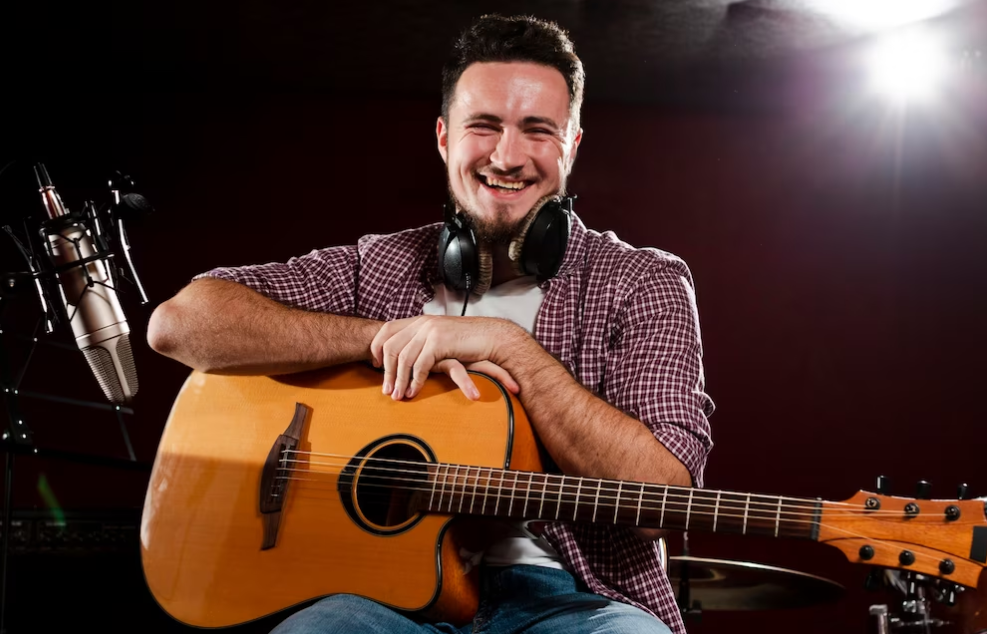 Hombre sosteniendo su guitarra y sonriendo