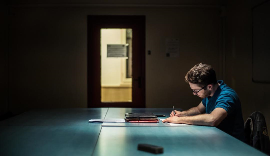 Un hombre escribiendo sobre la mesa