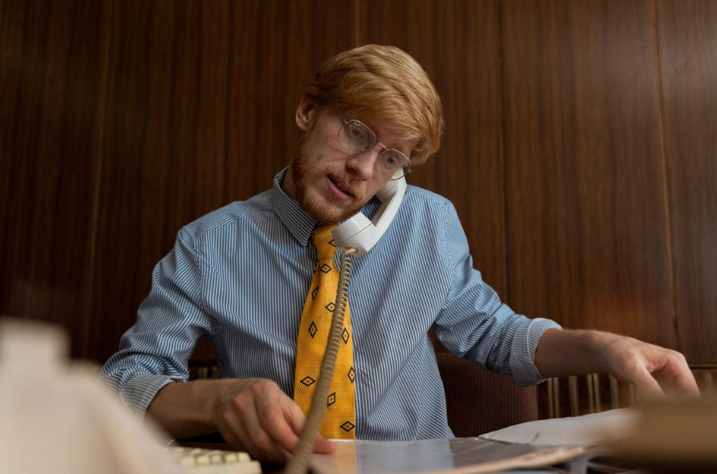 Hombre pelirrojo hablando por teléfono.