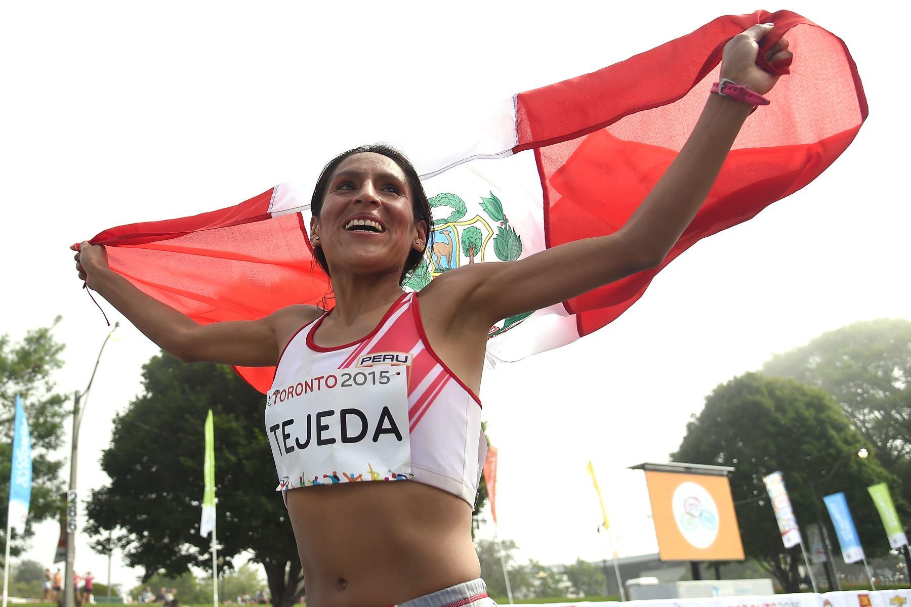 foto de Gladys sonriente sosteniendo la bandera peruana en la carrera de Toronto 2015