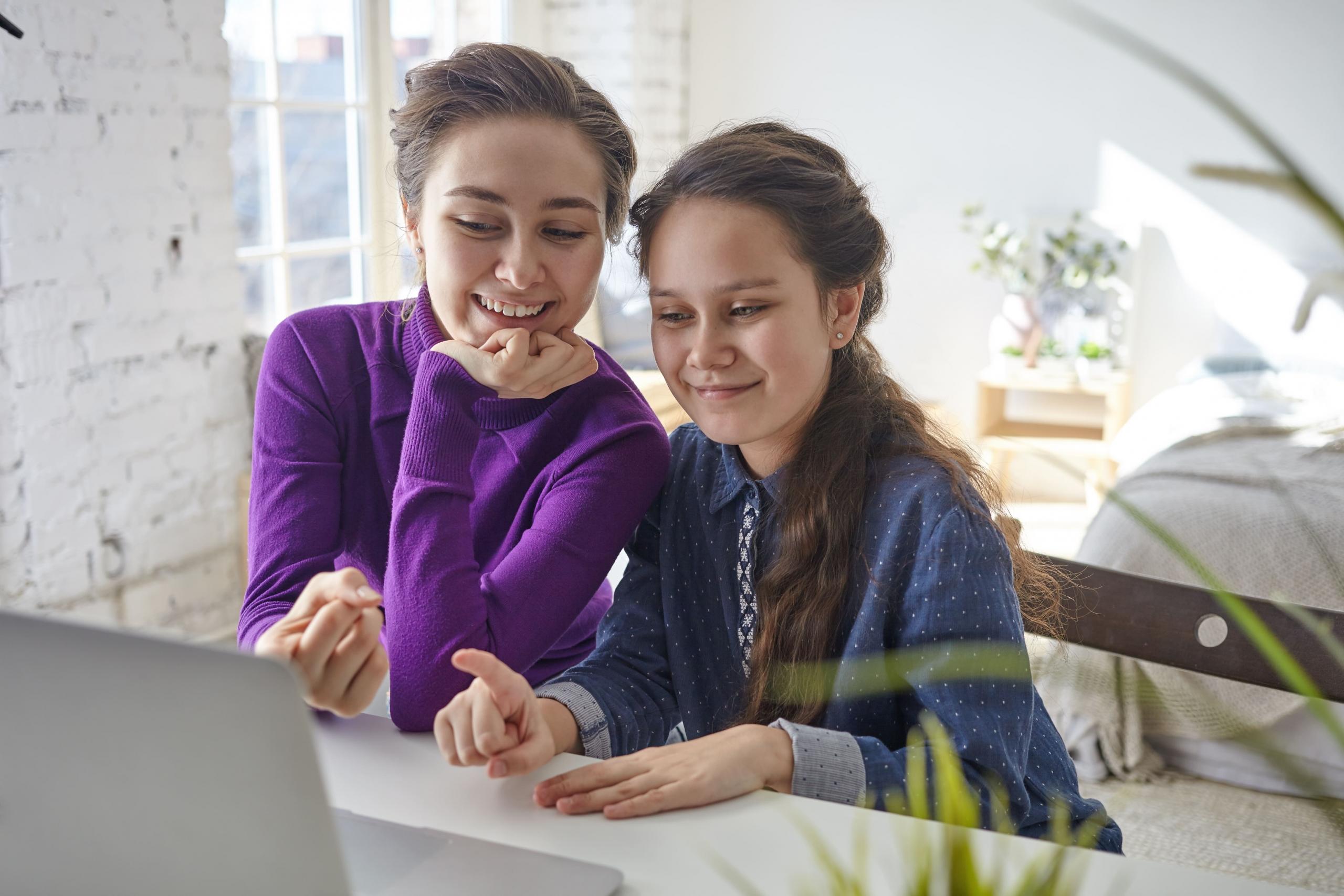 mujer y niña mirando unas clases en la pantalla de una laptop