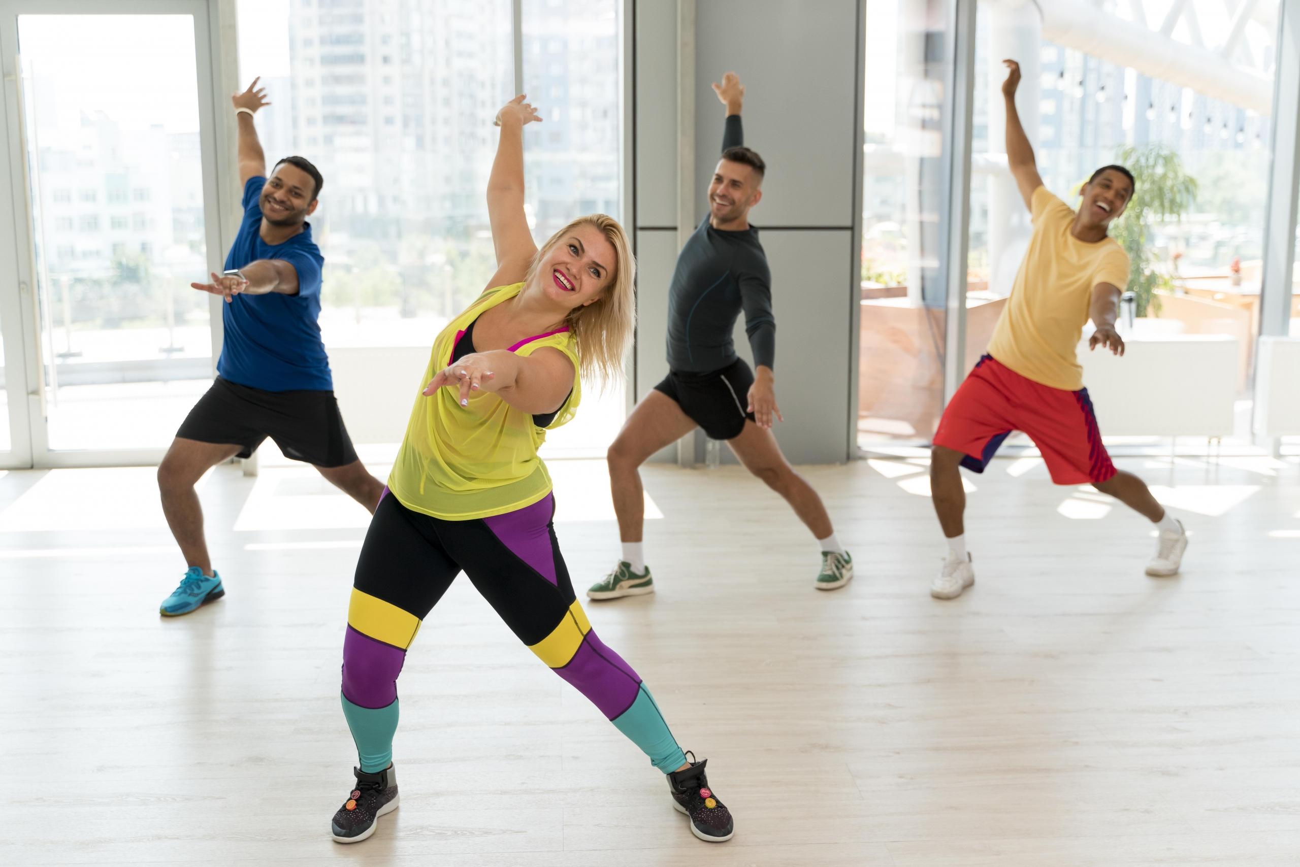 personas siguiendo pasos de baile de una instructora