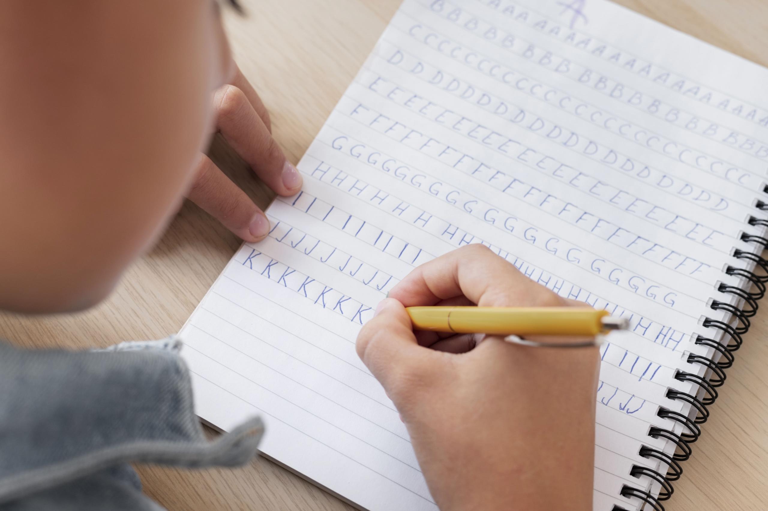 niño escribiendo una plana de caligrafía con las letras del abecedario