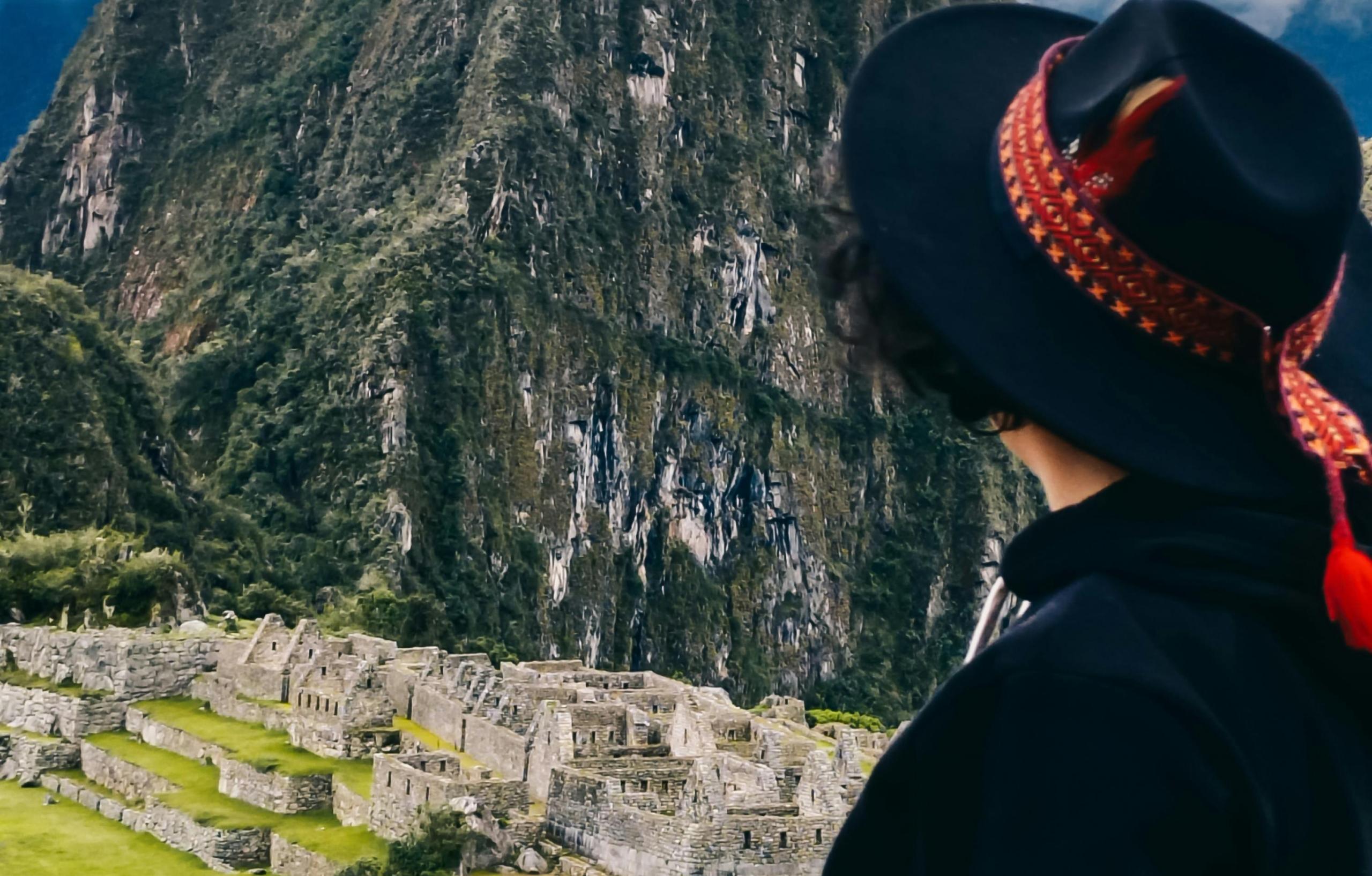chica con sombrero de espaldas miran Machu Picchu