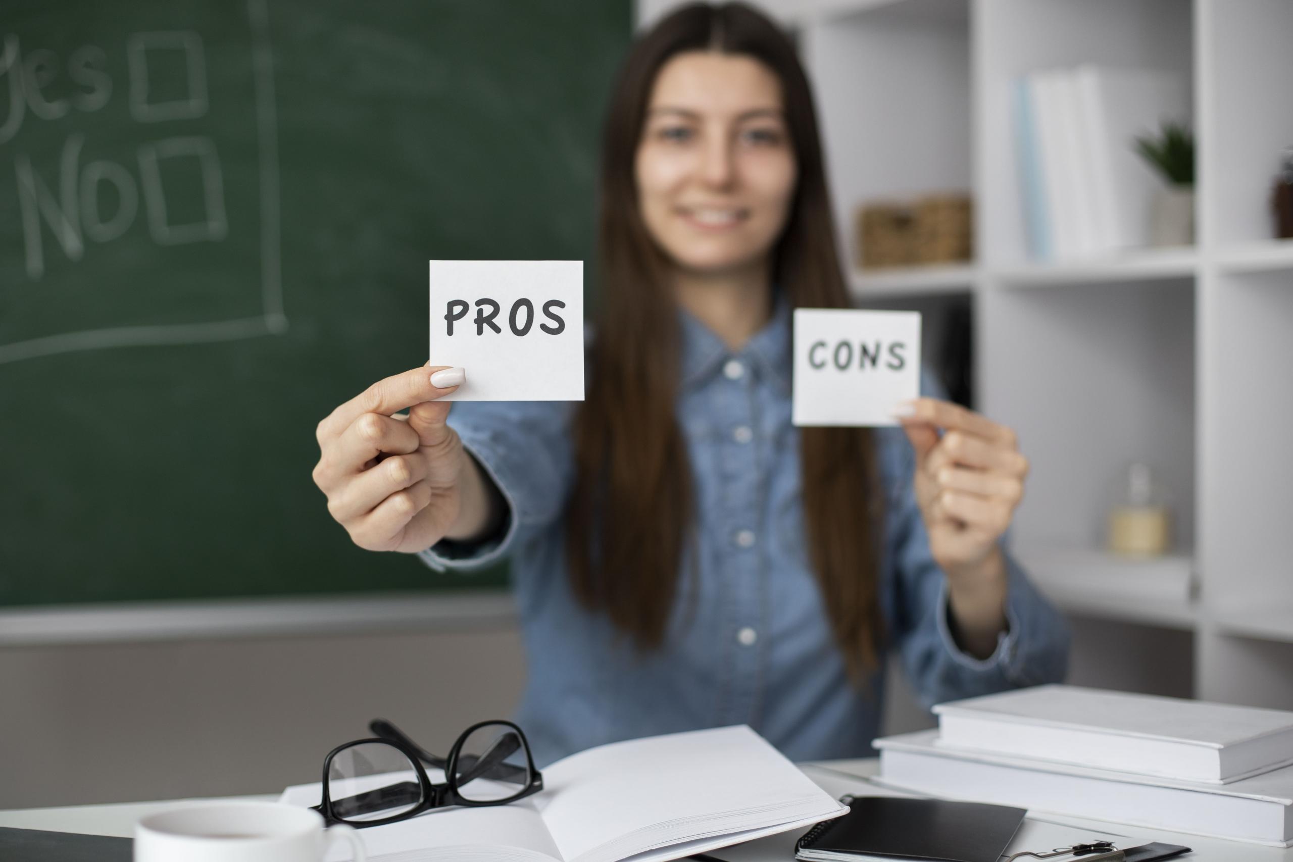 chica mostrando dos papelitos a la cámara con las palabras PROS y CONS