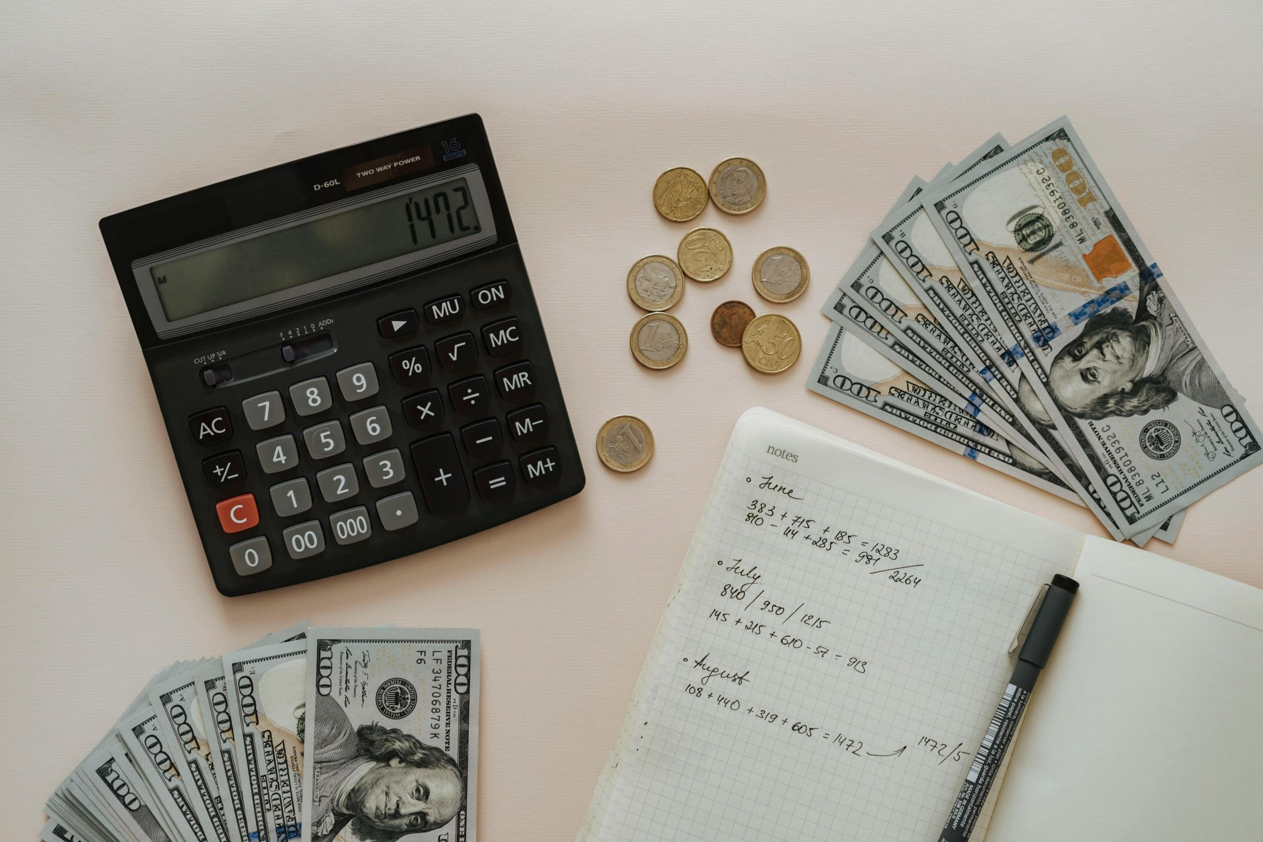 escritorio lleno de calculadora, dinero y anotaciones de numeros