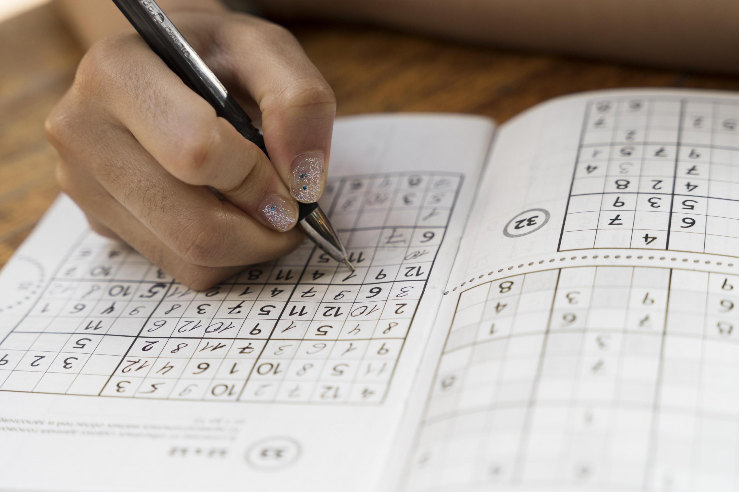 mano llenando una tabla de sudoku