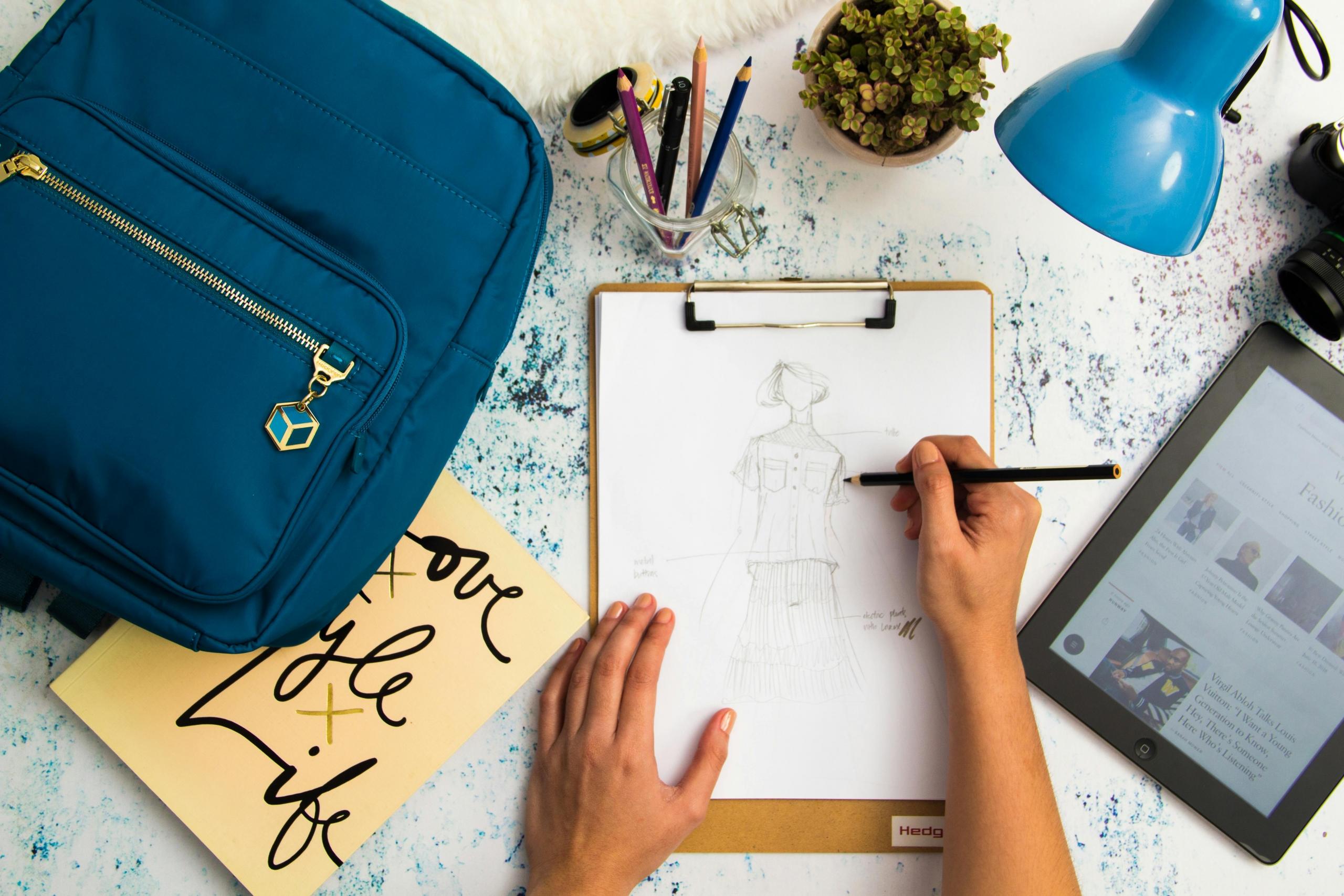 vista cenital de mano dibujando un boceto de diseño de moda