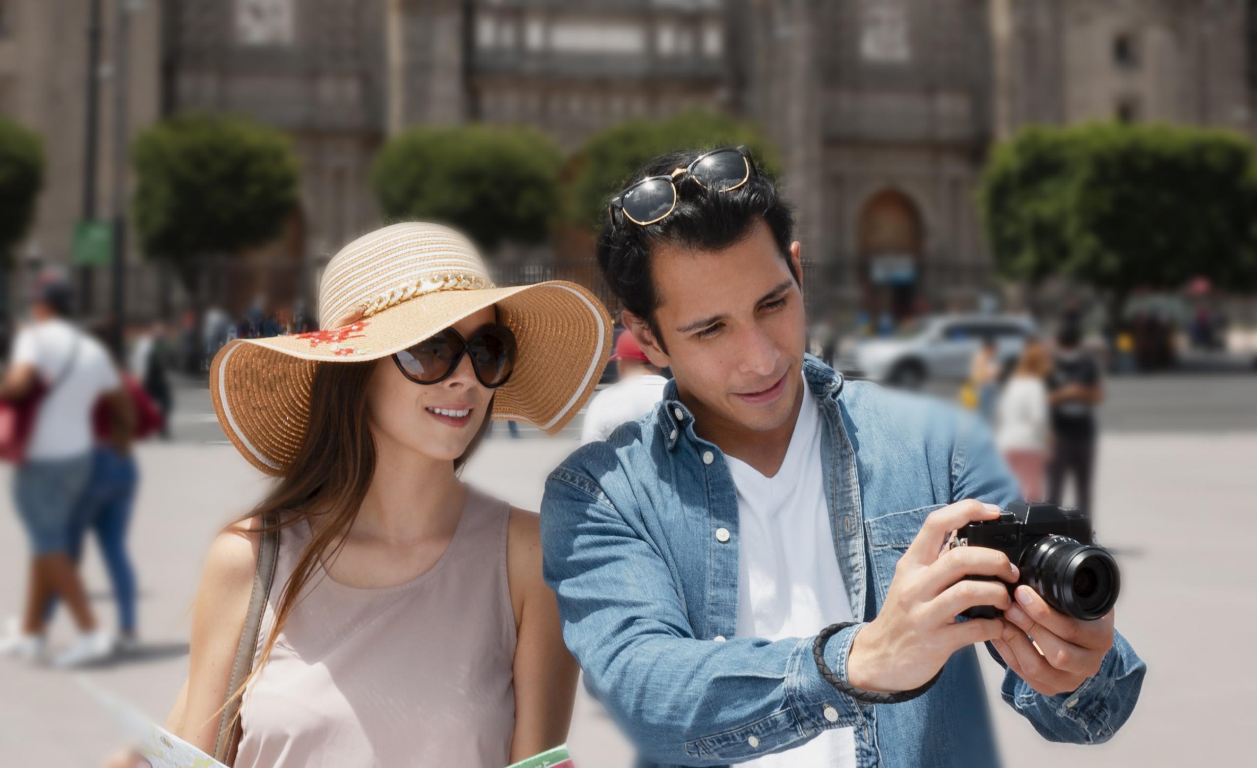 pareja mirando mirando una cámara en medio de una plaza