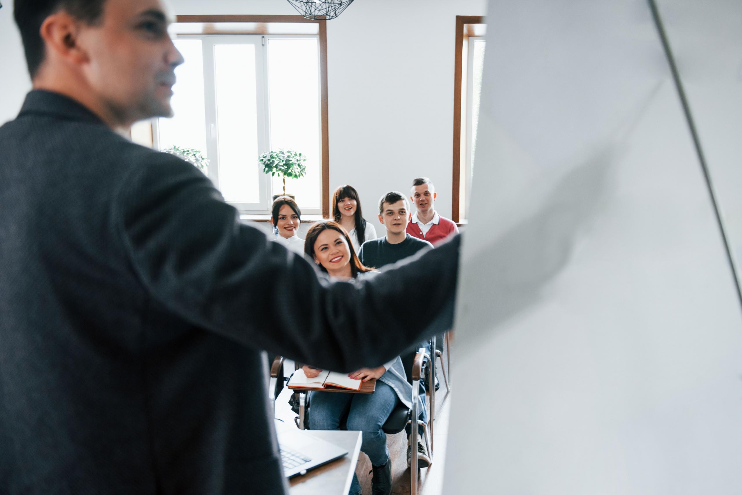 vista de espaldas de profesor dando clases a un grupo de universitarios