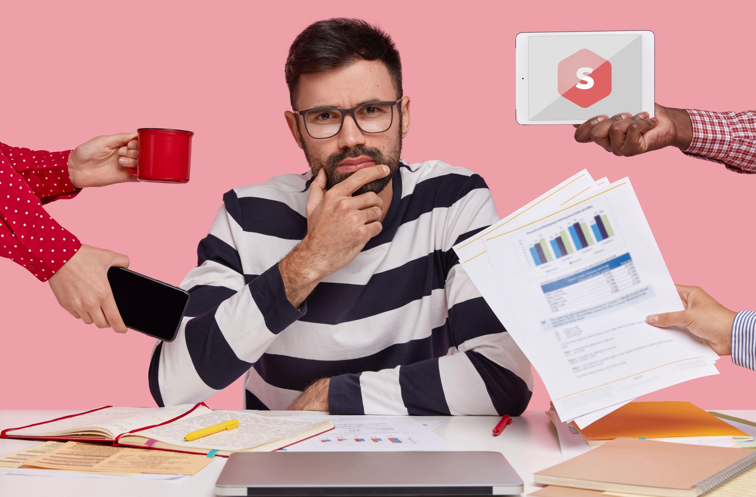 chico mirando a la cámara pensativo con varias manos entregándole diferentes cosas: taza de cafe, celular, tablet y hojas con informes