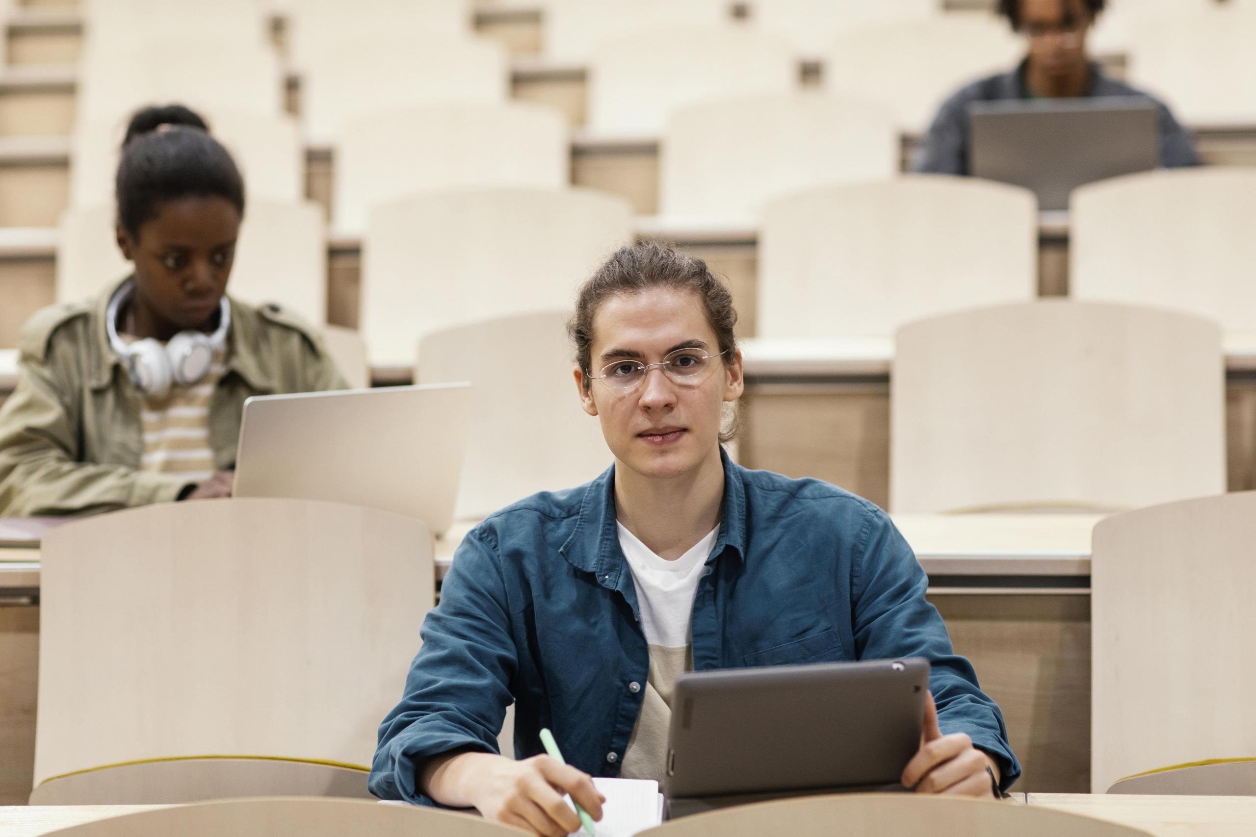 chico universitario en aula casi vacía